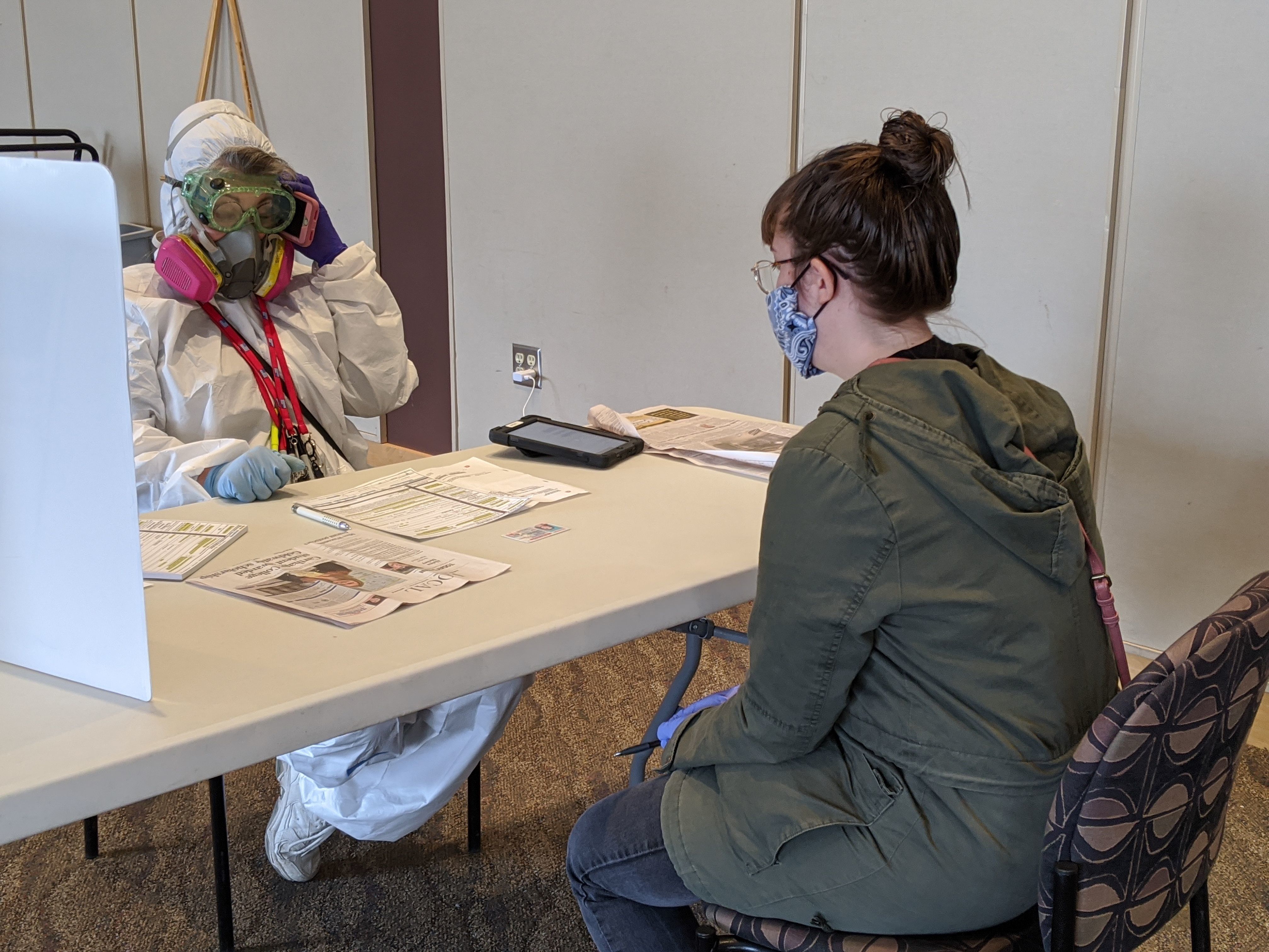 An election official in Kenosha, Wis., with a voter on April 7. Nearby Milwaukee says it's recorded at least seven coronavirus cases related to the state's controversial decision to move forward with in-person voting. (AFP via Getty Images)