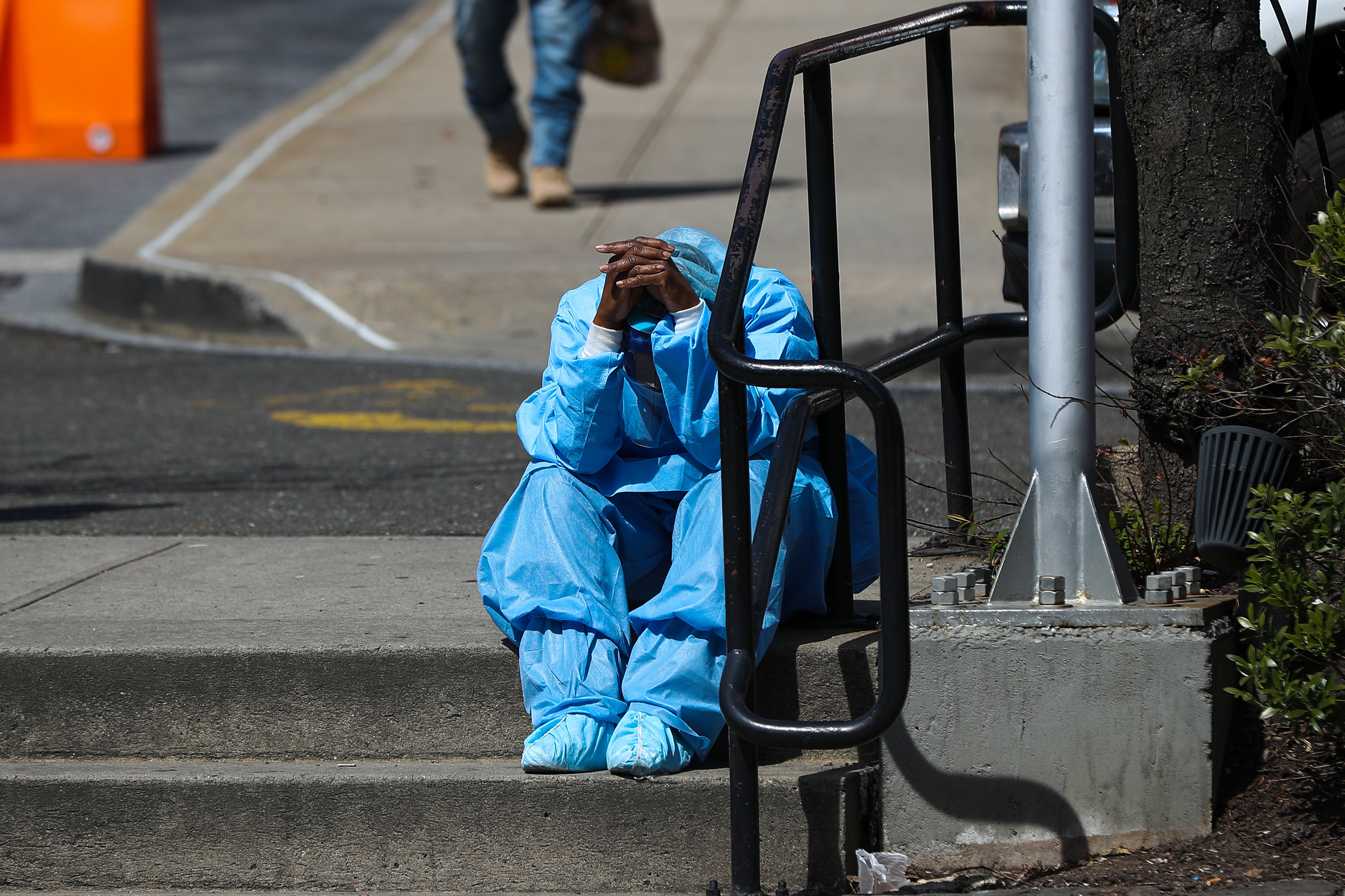 A fatigued health care worker takes a moment outside the Brooklyn Hospital Center in April. Many hospital workers these days have to cope with horrific tragedies playing out multiple times on a single, 12-hour shift. (Anadolu Agency via Getty Images)