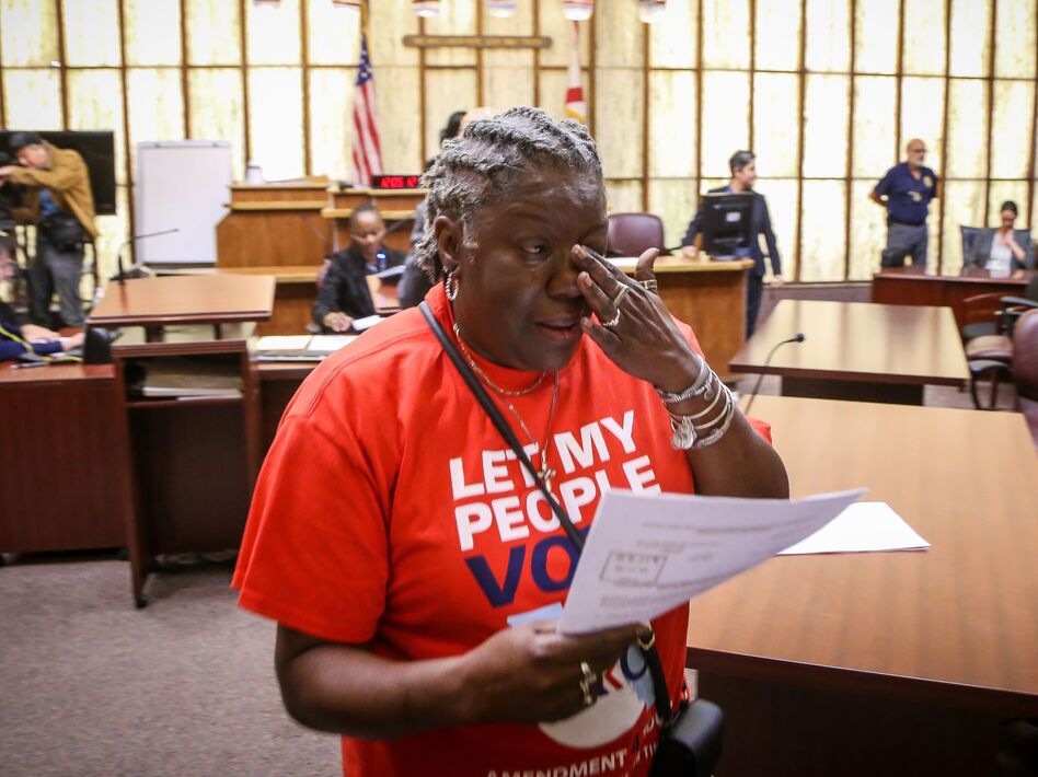 Carmen Brown weeps as she walks away holding a paper restoring her right to vote during a special court hearing aimed at restoring that right in a Miami-Dade County courtroom on Nov. 8, 2019. A federal lawsuit currently underway would make it easier for others to get their voting rights restored by eliminating requirements that they pay fines and fees. (Zak Bennett/AFP via Getty Images)