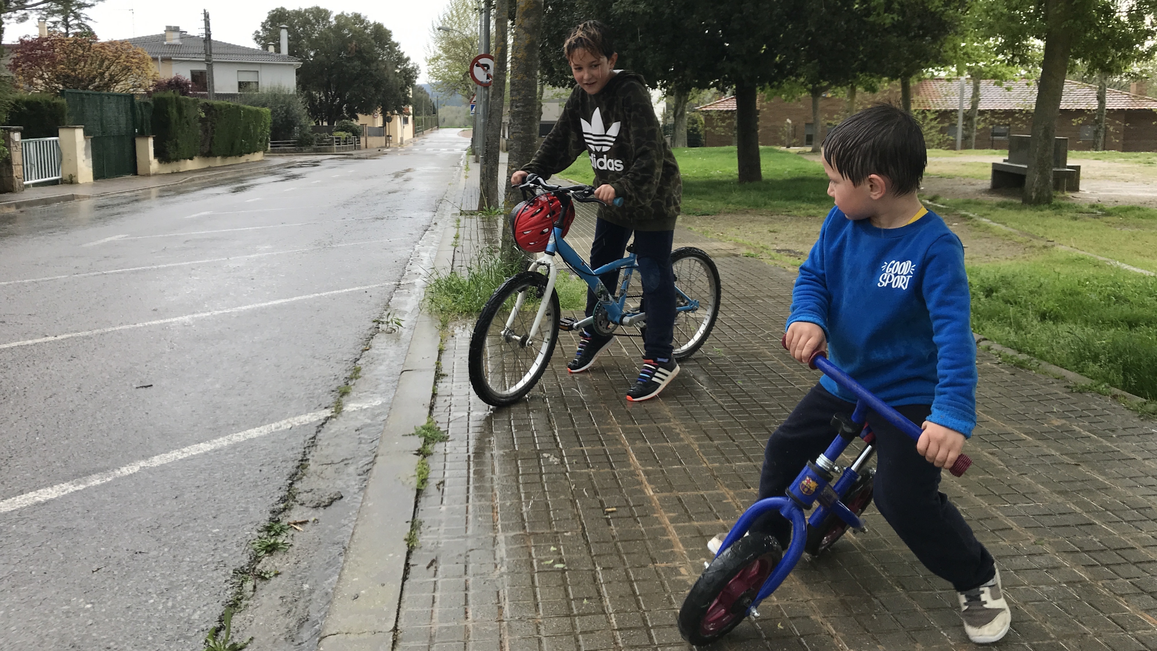 Bruno, 8, and younger brother Alan, 4, ride their bikes in Moià, a town about an hour and a half outside Barcelona. Spain has eased restrictions that kept children from leaving their homes.