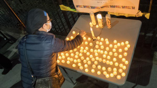 The U.S. death toll from COVID-19 hit a new milestone, surpassing the number of Americans who died in the prolonged conflict with Vietnam. Here, the Elmhurst Hospital Center in Queens, N.Y., holds a vigil for medical workers and patients who have died in the pandemic.