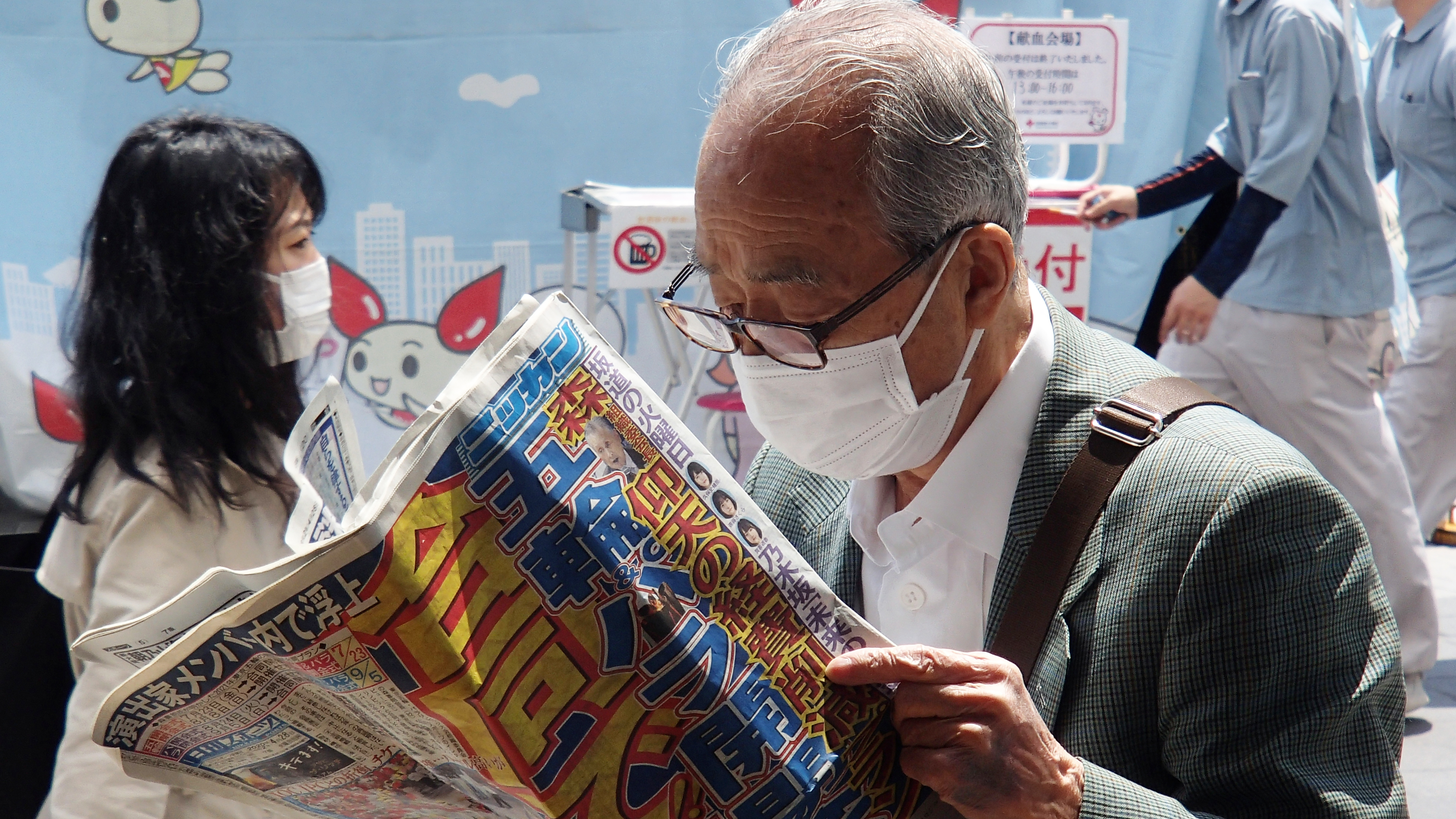 A man reads a sports newspaper on the street amid the COVID-19 pandemic in Tokyo, on Tuesday.