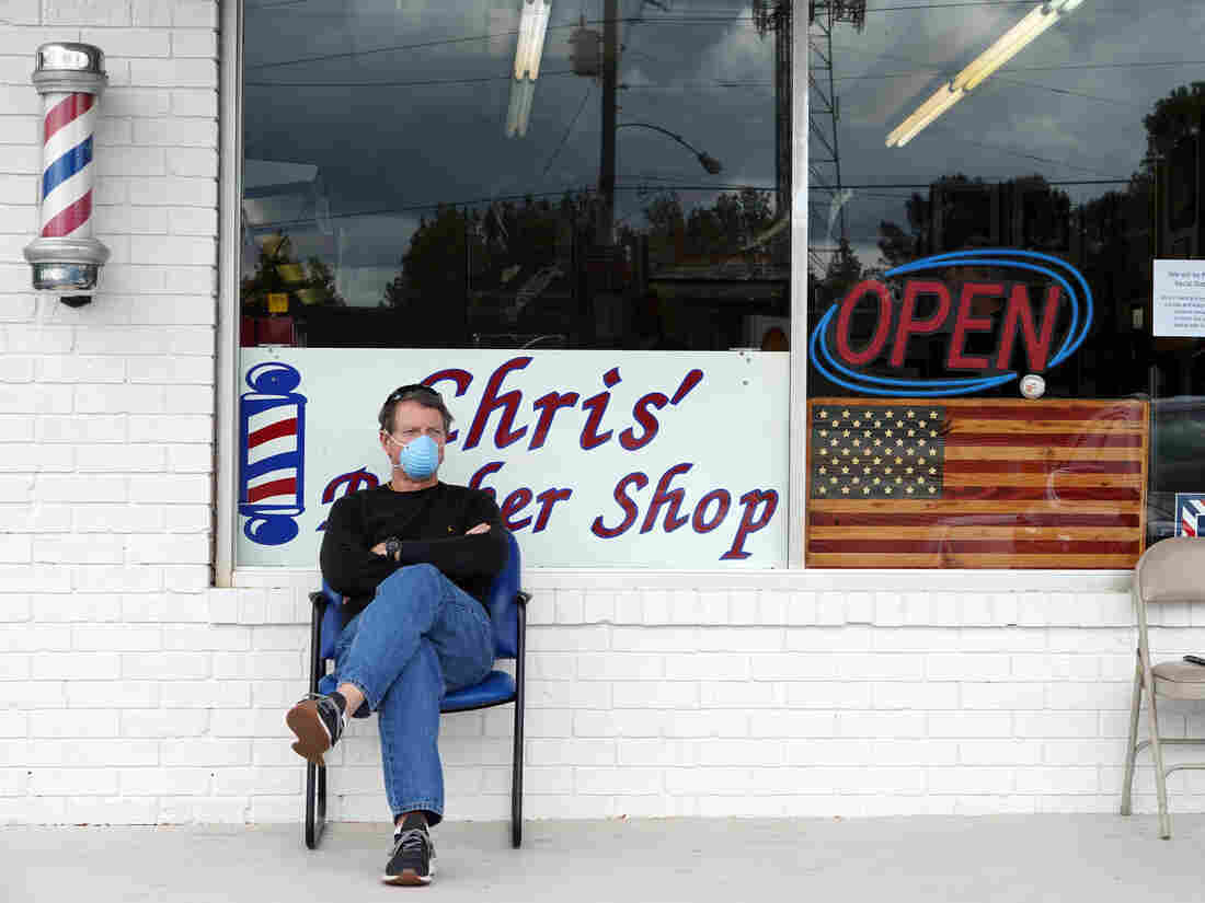 Dan Settle sits outside Chris' Barber Shop as he waits his turn for a haircut in Lilburn, Georgia on April 24, 2020. - Georgia Governor Brian Kemp eased restrictions allowing some businesses such as barber shops to reopen to get Georgia's economy going during the coronavirus pandemic. (Photo by Tami Chappell / AFP) (Photo by TAMI CHAPPELL/AFP via Getty Images)