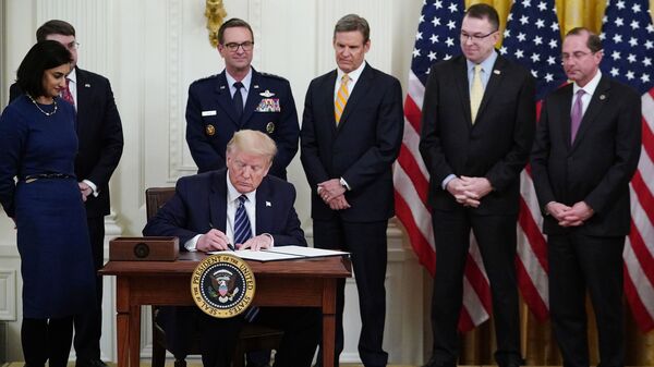 President Trump, surrounded by federal officials on Thursday, signs a proclamation for Older Americans Month during an event on protecting seniors from the coronavirus.