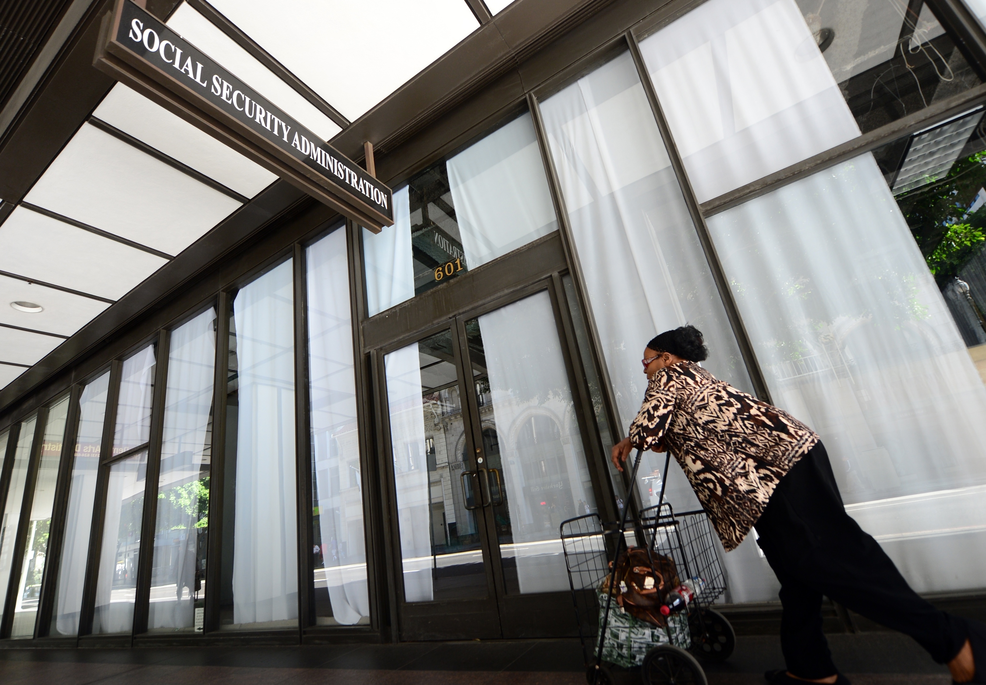 A woman passes a closed Social Security Administration office in Los Angeles in 2013. Some 53,000 of the agency's workers are now working from home. (AFP via Getty Images)