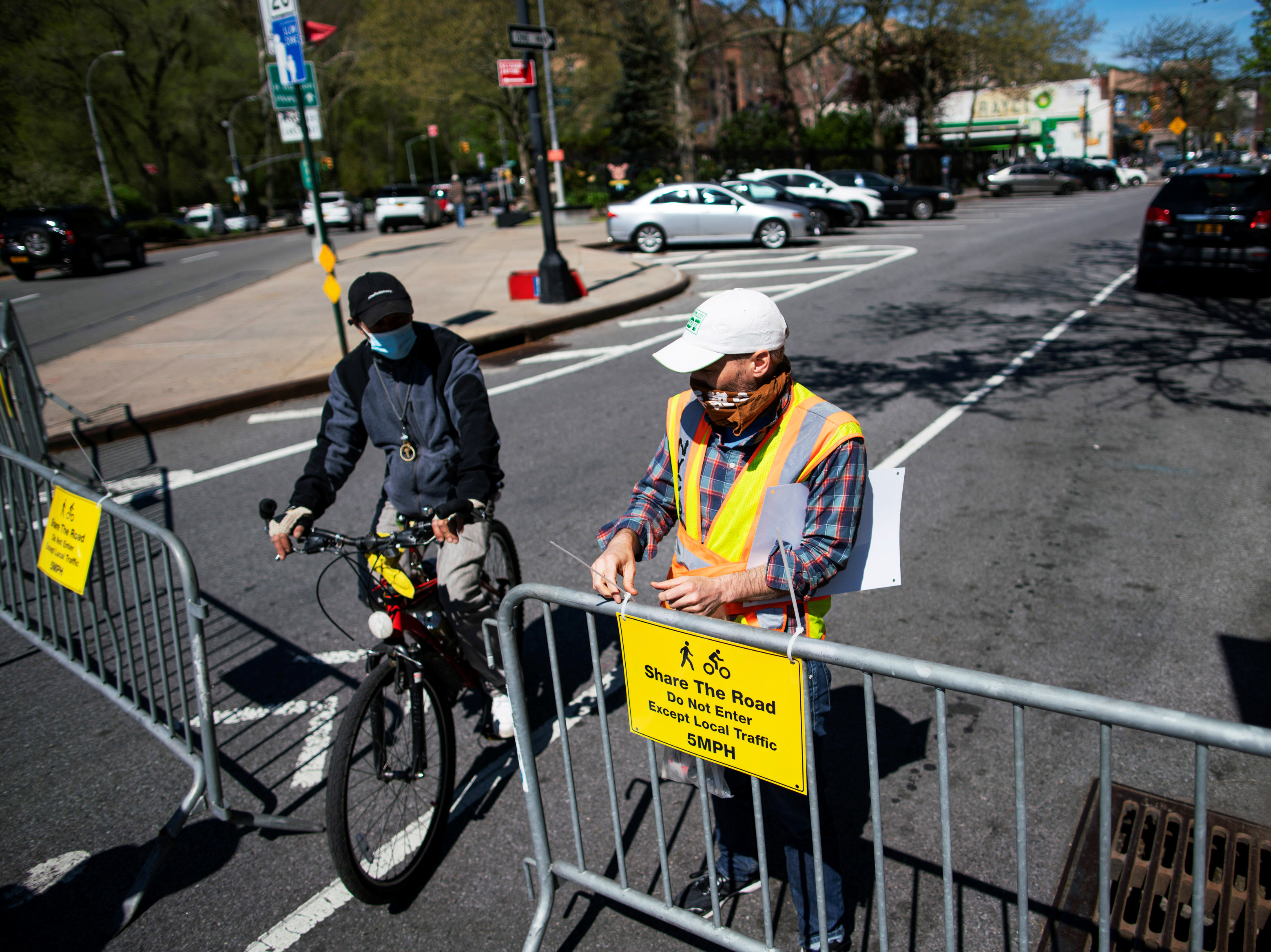 A New York City worker closes a street to car traffic in Manhattan on Saturday so that pedestrians and cyclists can maintain social distancing. Mayor Bill de Blasio said 100 miles will be closed to car traffic in the coming weeks. (Reuters)