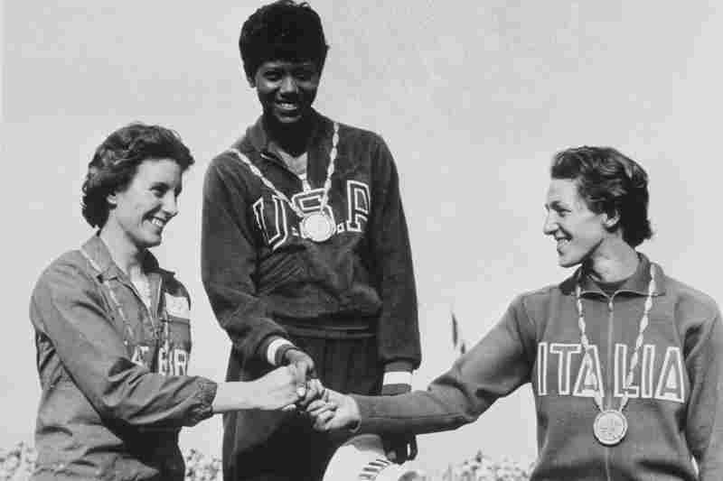 3 AUG 1960: WILMA RUDOLPH OF THE USA, MIDDLE, STAND ON THE AWARDS STAND WITH COMPETITORS DOROTHY HYMAN, LEFT, AND G. LEONE AFTER WINNING THE GOLD MEDAL IN THE 200 METER SPRINT AT THE SUMMER OLYMPICS IN ROME, ITALY. Mandatory Credit: HULTON DEUTSCH/ALL