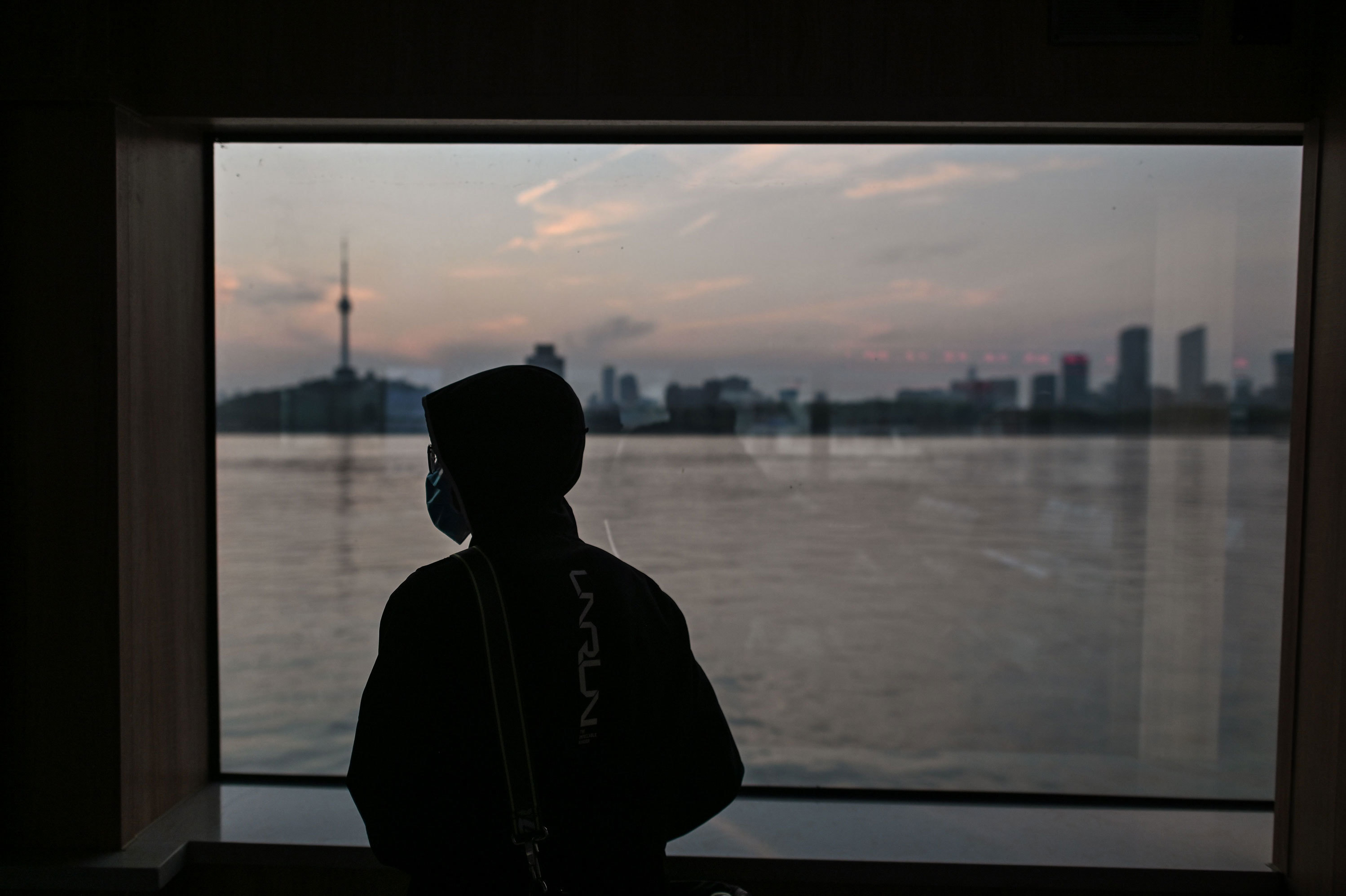 A man wearing a face mask travels on a ferry to cross the Yangtze River in Wuhan in April. Chinese officials are working to silence people suspected of challenging the narrative that authorities in Wuhan and Beijing acted swiftly and efficiently to contain the coronavirus outbreak. (AFP via Getty Images)