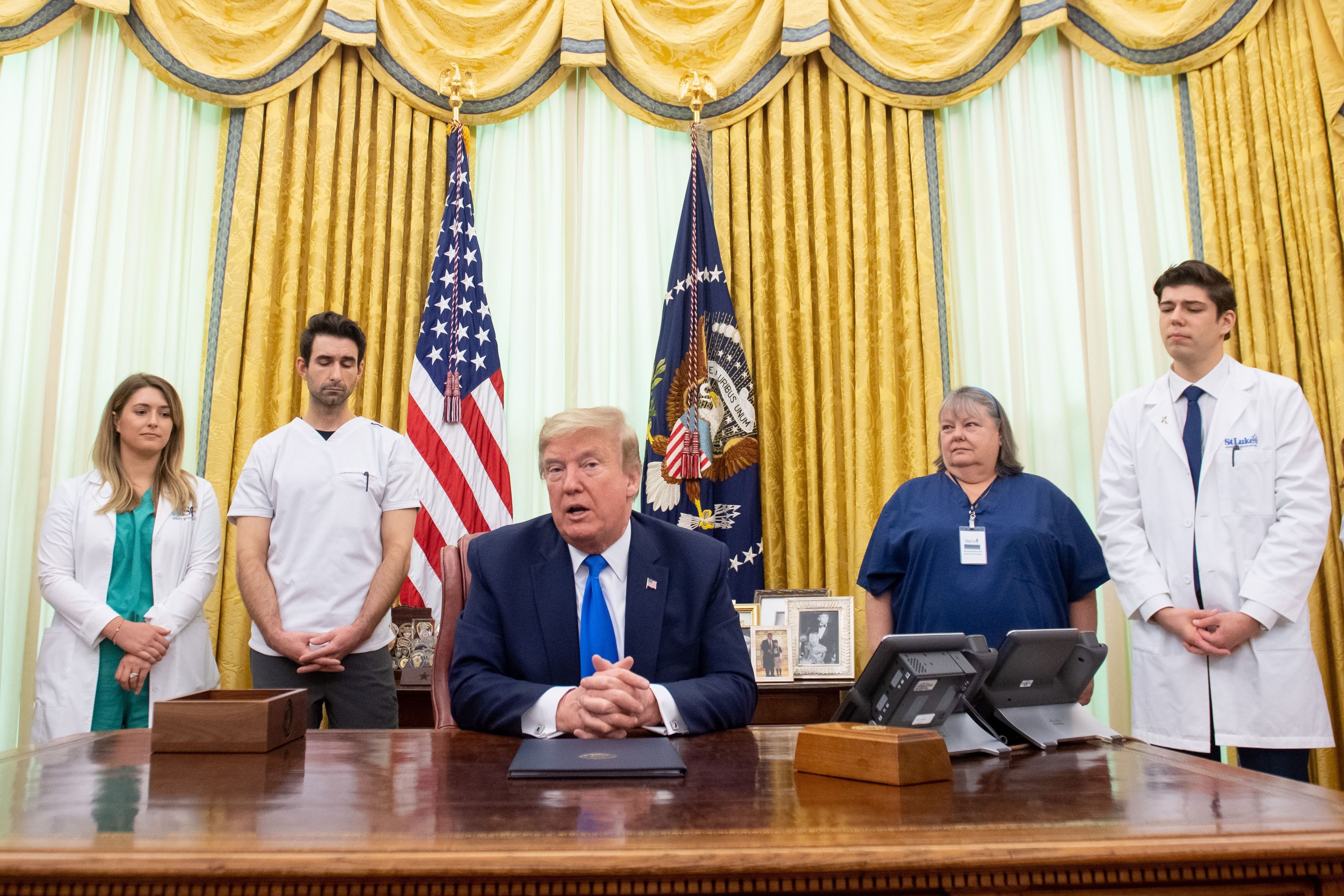 President Trump speaks about COVID-19 alongside nurses after signing a proclamation in honor of National Nurses Day in the Oval Office of the White House on Wednesday. Trump and Vice President Pence have not worn face masks during public events, which goes against the administration's recommendations. (AFP via Getty Images)