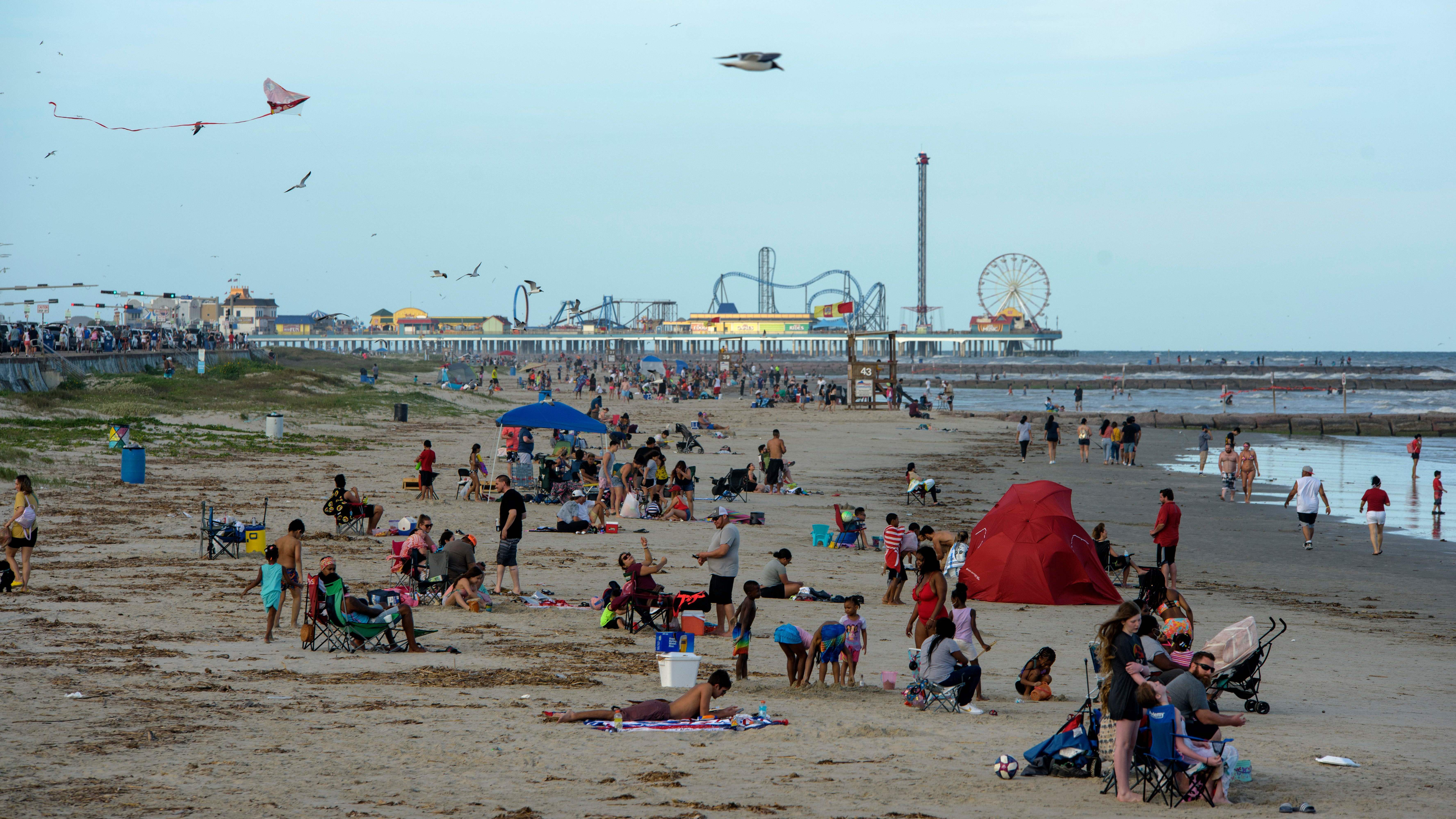 Beachgoers enjoy a day at Galveston Beach on May 2 in Galveston, Texas, amid the coronavirus pandemic. As states have started to reopen, people have begun gathering again.
