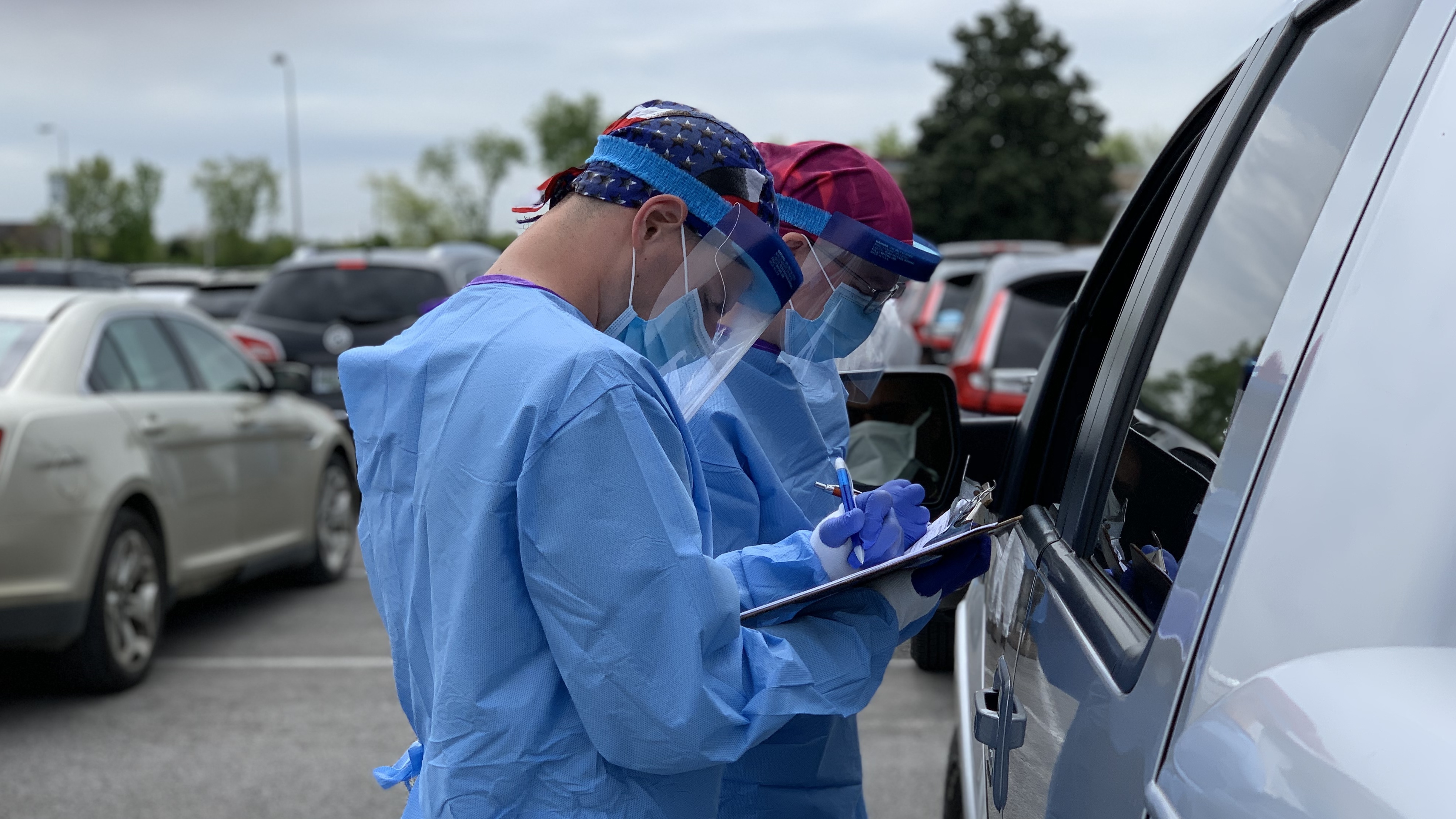 A nurse and National Guard medic interview a patient before taking a swab for a coronavirus test last month at Gallatin High School in Gallatin, Tenn. The state of Tennessee started picking up the tab for testing in April.