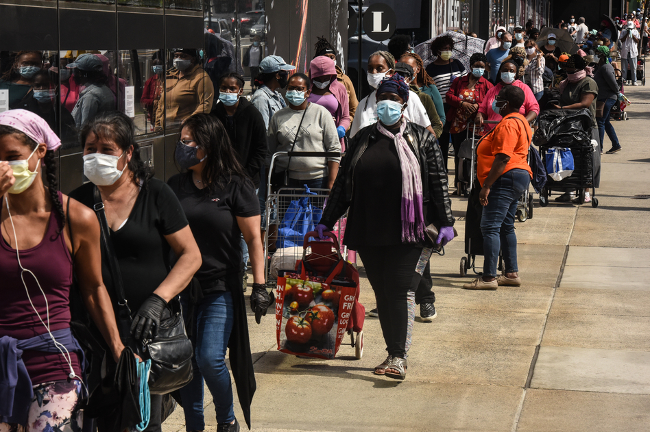 People wait in a long line to receive a food bank donation at the Barclays Center on May 15 in Brooklyn, N.Y. Across the country, cities and towns are dealing with the highest unemployment rates since the Great Depression. (Stephanie Keith/Getty Images)