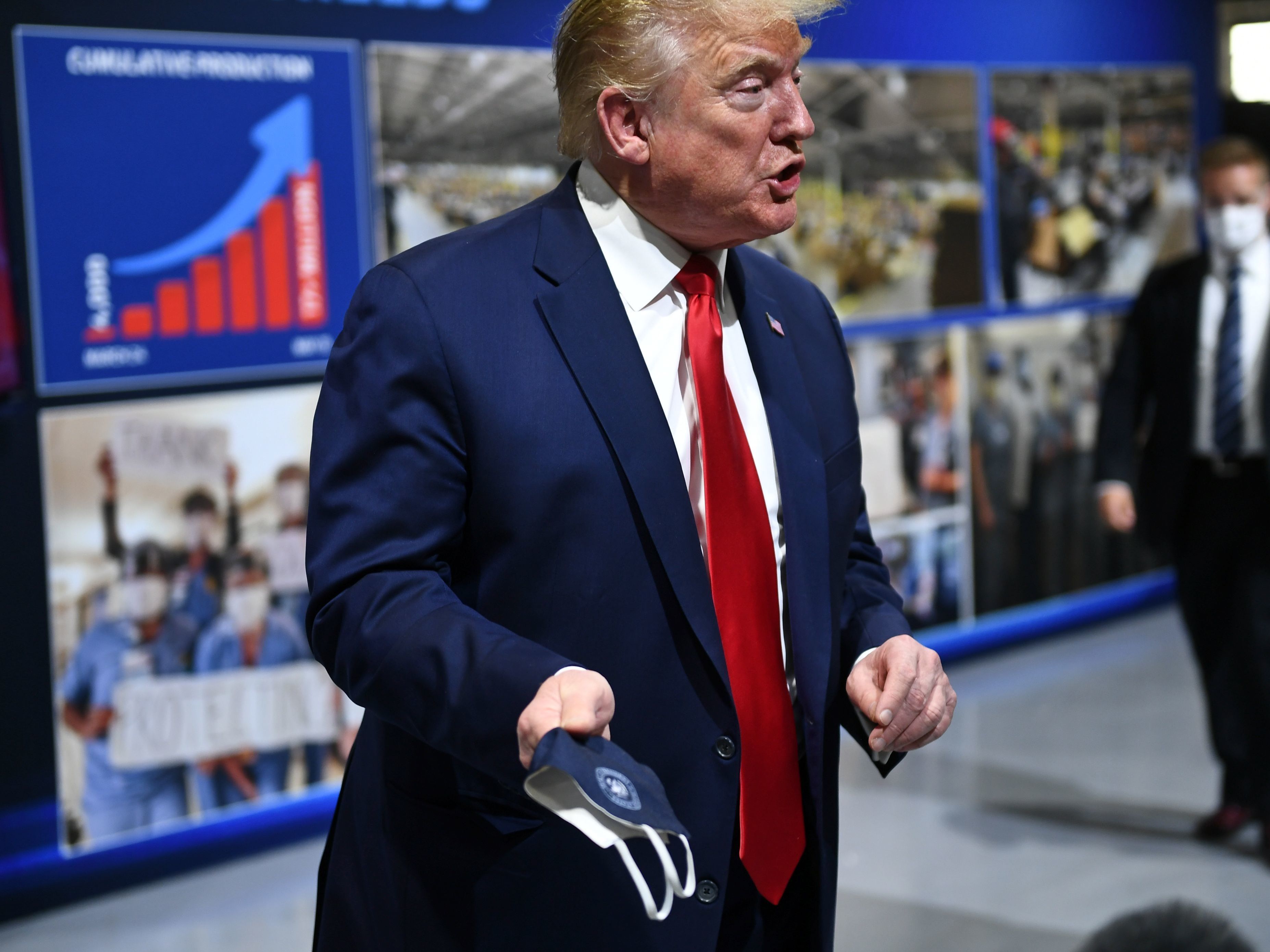 President Trump holds a mask as he speaks during a tour of Ford's Rawsonville Plant in Ypsilanti, Mich., on Thursday. (AFP via Getty Images)