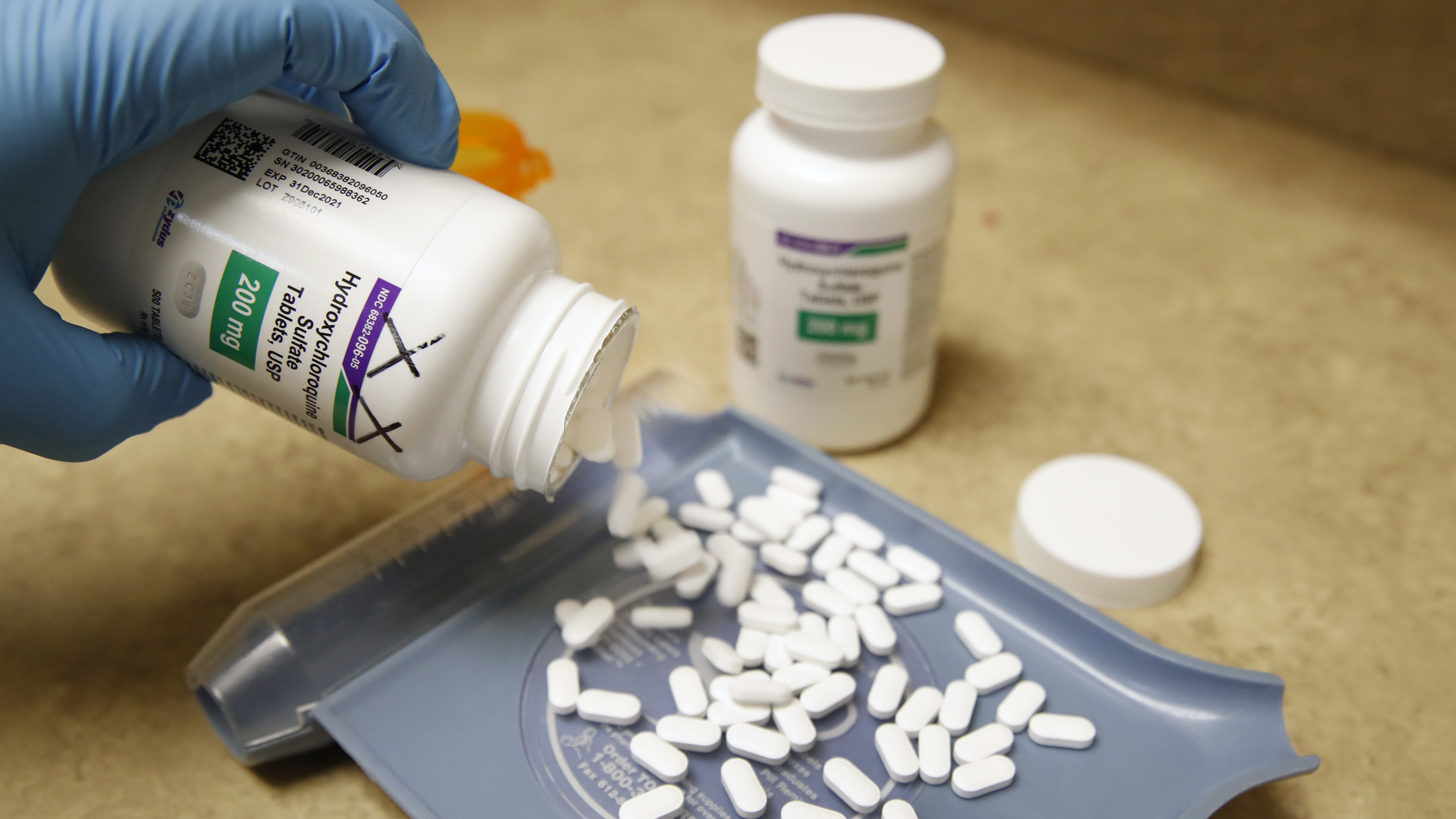 A pharmacy tech pours out pills of hydroxychloroquine May 20 at Rock Canyon Pharmacy in Provo, Utah, on May 20, 2020. After a study found COVID-19 patients using the drug were dying at higher rates, the World Health Organization announced it would suspend its clinical trial.