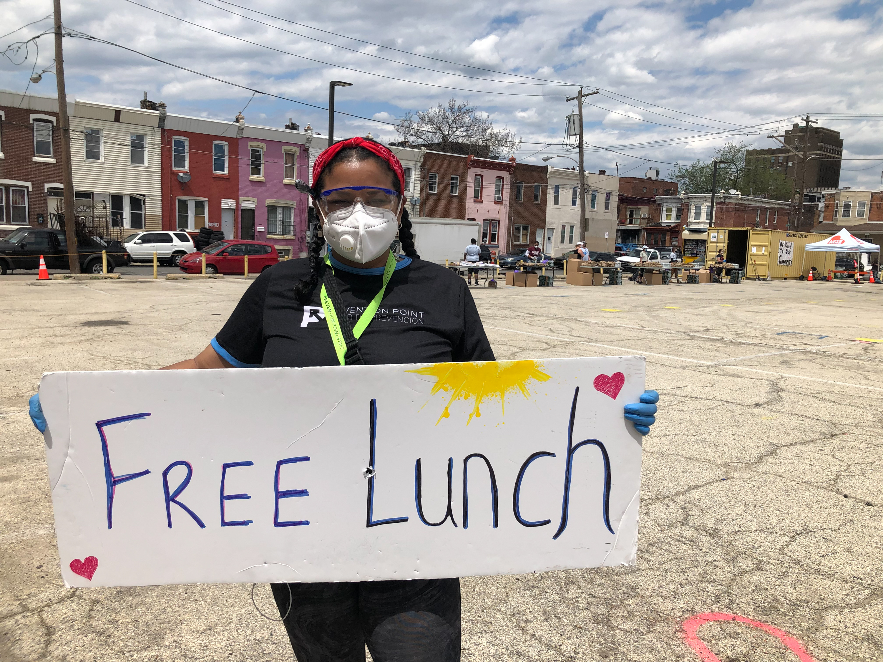Rosalind Pichardo advertises a daily food giveaway service in the heart of Philadelphia's Kensington neighborhood, where more people die of opioid overdoses than any other area in the city. (Nina Feldman/ WHYY)