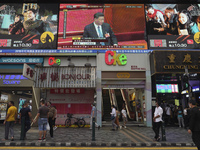Pedestrians in Hong Kong walk under a giant screen showing a live telecast of Chinese President Xi Jinping, at the closing session of the National People's Congress on Thursday.