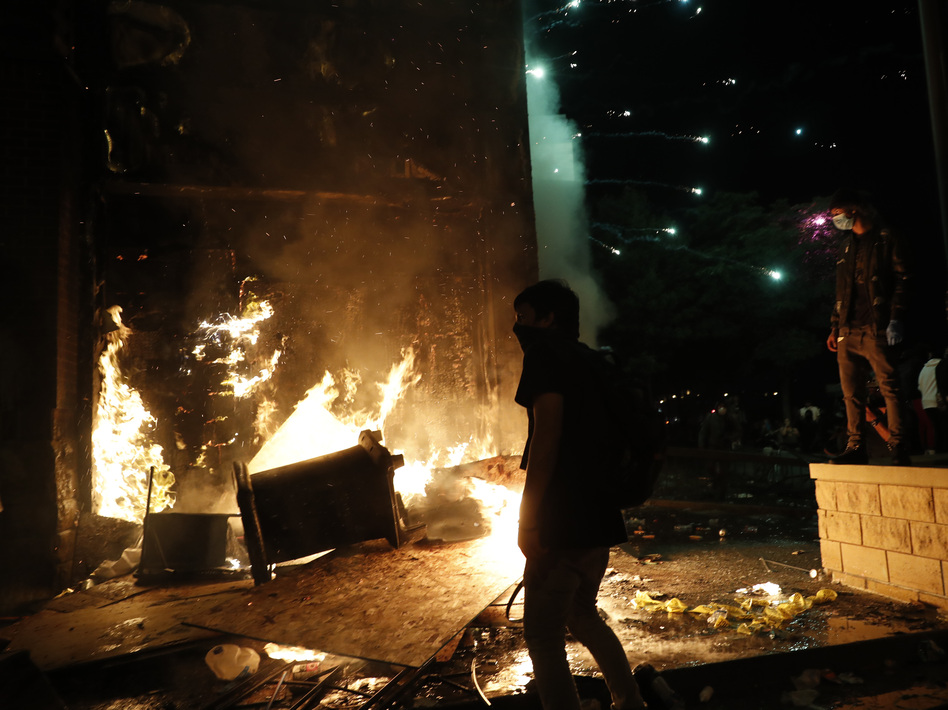 Protesters set fires at the 3rd Precinct of the Minneapolis Police Department on Thursday. Protests over the death of George Floyd, the black man who died in police custody, continued in Minneapolis for a third straight night. (John Minchillo/AP)