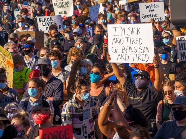 Protesters hold signs during a demonstration in a call for justice for George Floyd who died while in custody of the Minneapolis police, on May 30, 2020 by the 5th police precinct in Minneapolis, Minnesota.