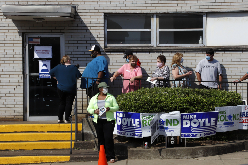 Voters stand in line as they wait to cast their ballots during primary voting in Braddock, Pa., on Tuesday. Problems with absentee ballots and a smaller number of polling places led to long lines in several states as primary elections that were delayed by the coronavirus resumed. (Gene J. Puskar/AP)