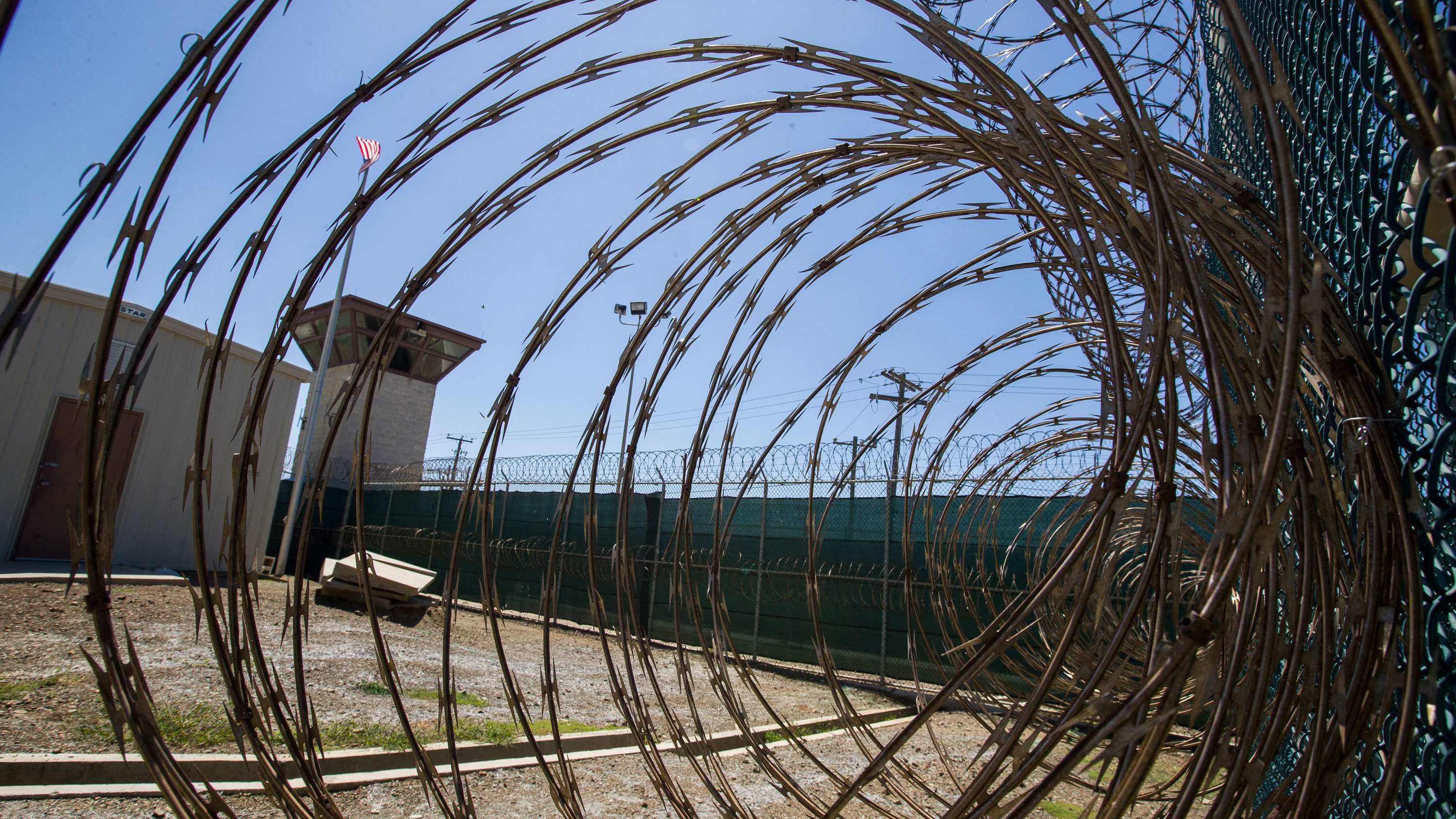 In this photo reviewed by U.S. military officials, the control tower is seen through the razor wire inside the Camp VI detention facility, Wednesday, April 17, 2019, in Guantanamo Bay Naval Base, Cuba.
