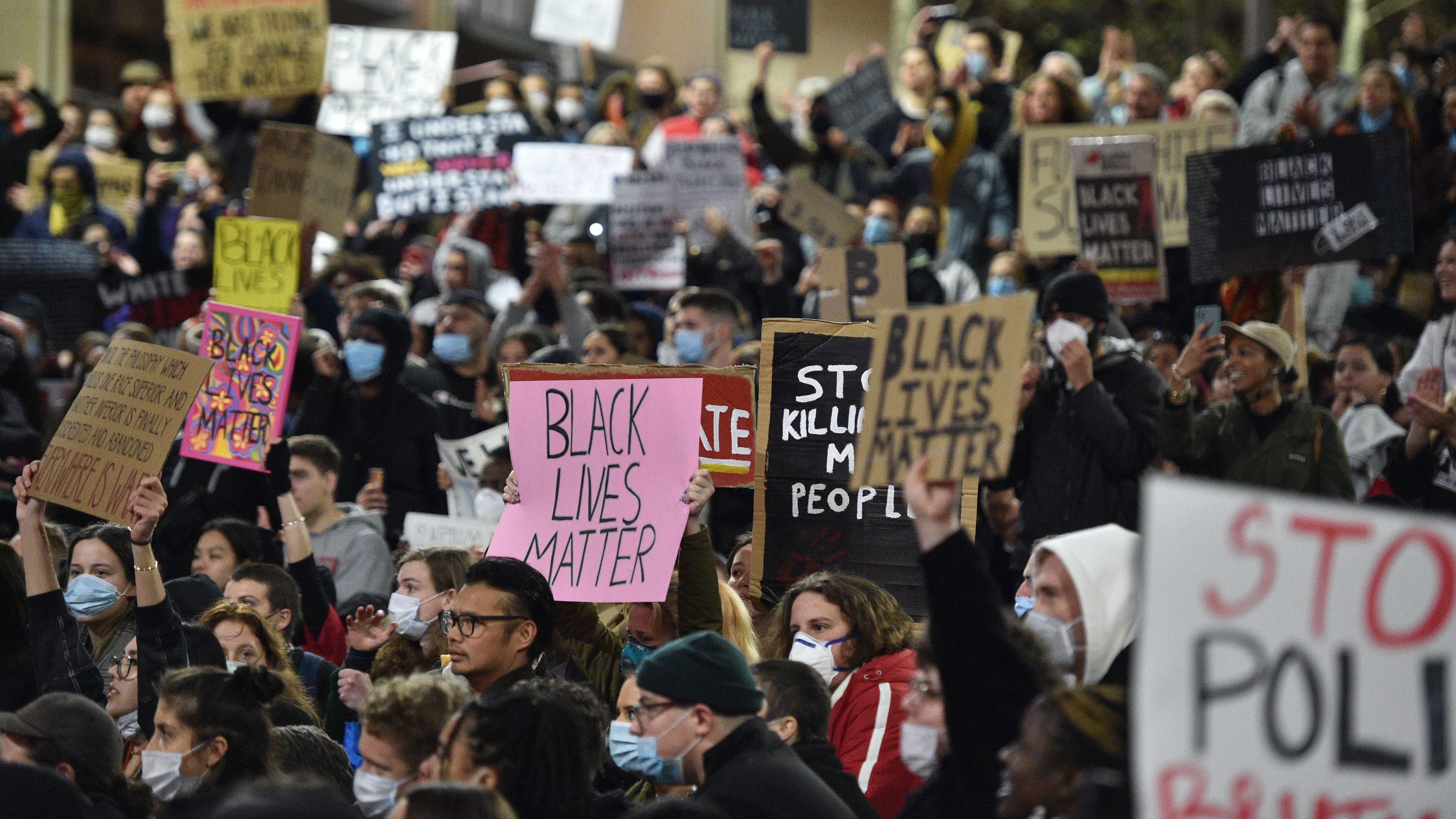 Marchers shout slogans and hold up placards Tuesday during a "rally for justice" in Sydney, protesting the deaths of members of the Aboriginal community in Australia and the death of George Floyd, an unarmed black man who died in police custody in Minneapolis. Minn.