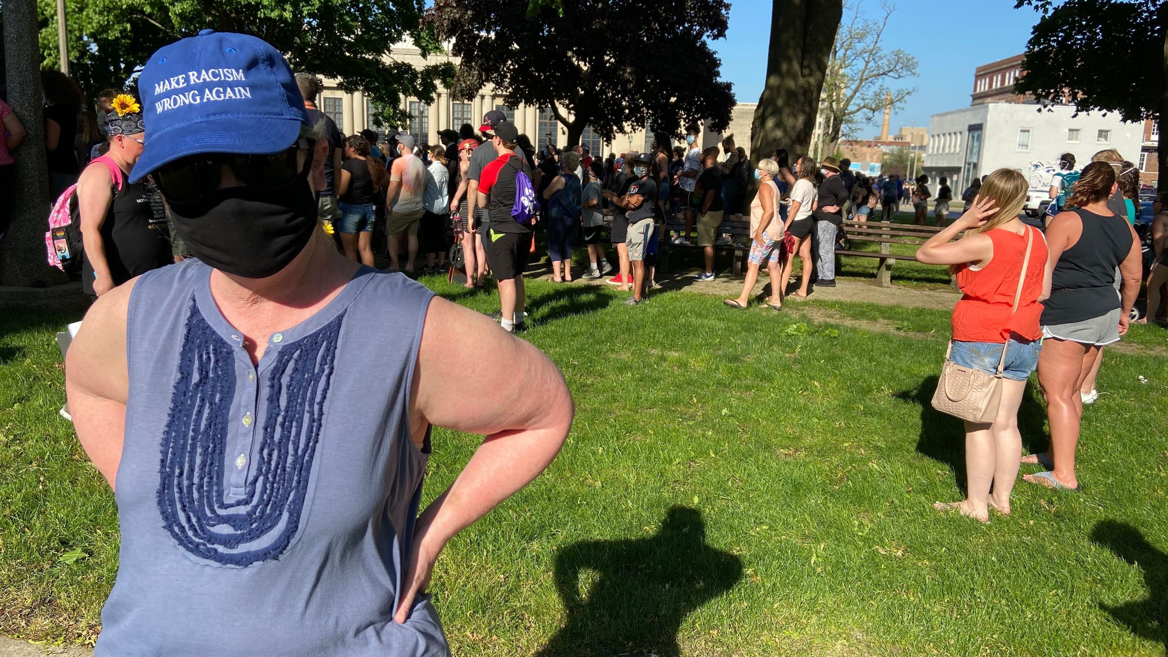 Wearing a mask to protect herself from the coronavirus and a hat that reads &quot;Make Racism Wrong Again,&quot; Lydia Spottswood joins a protest in Kenosha, Wis., in response to George Floyd's killing by police. She thinks people are tired of President Trump's &quot;meanness.&quot; (NPR)