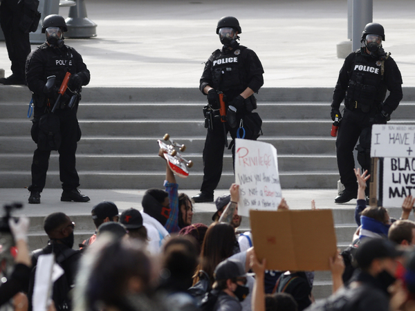 Denver Police observe the crowd during a protest outside the State Capitol on Saturday, May 30, 2020, in Denver.