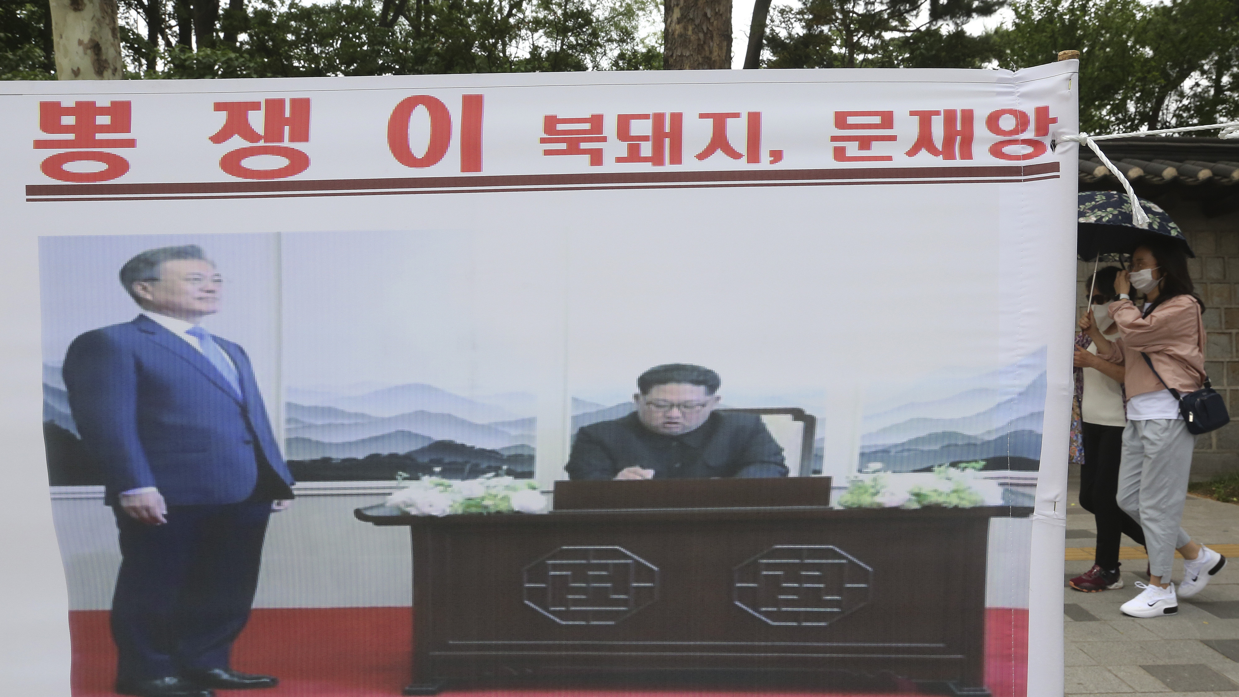 A banner showing a photo of North Korean leader Kim Jong Un and South Korean President Moon Jae-in, left, was displayed to denounce policies of Moon on North Korea in Seoul, South Korea.
