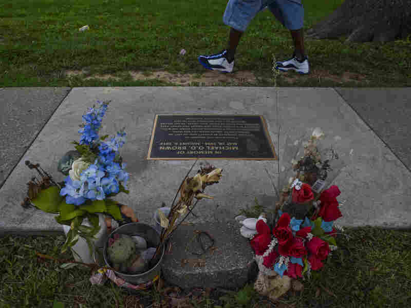 FERGUSON, MO - : A plaque in memory of teenager Mike Brown is embedded in the sidewalk near the Canfield Apartments where Mike Brown killed.
