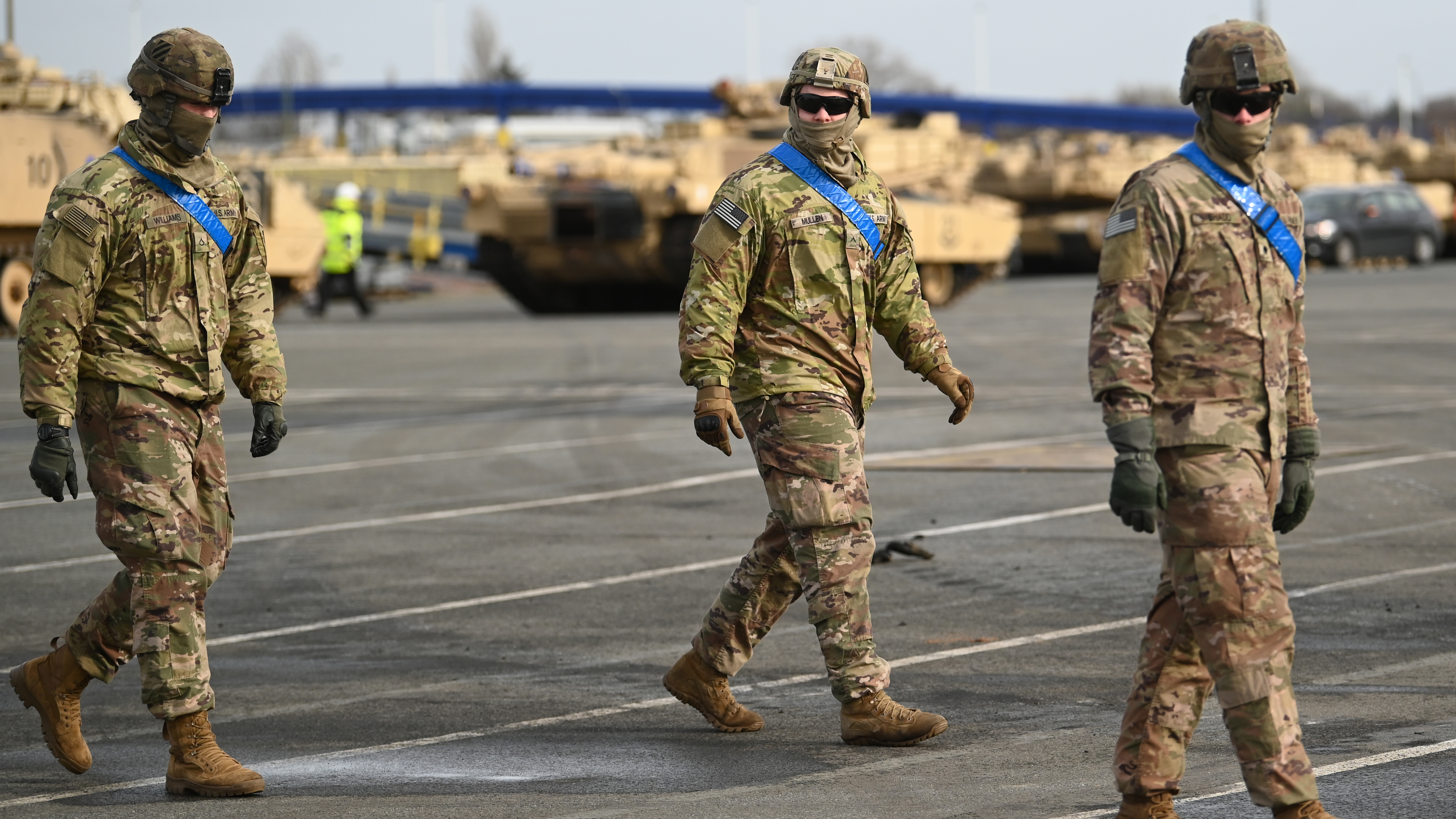 U.S. soldiers walk alongside tanks from the U.S. 2nd Brigade Combat Team, 3rd Infantry Division, parked at Germany