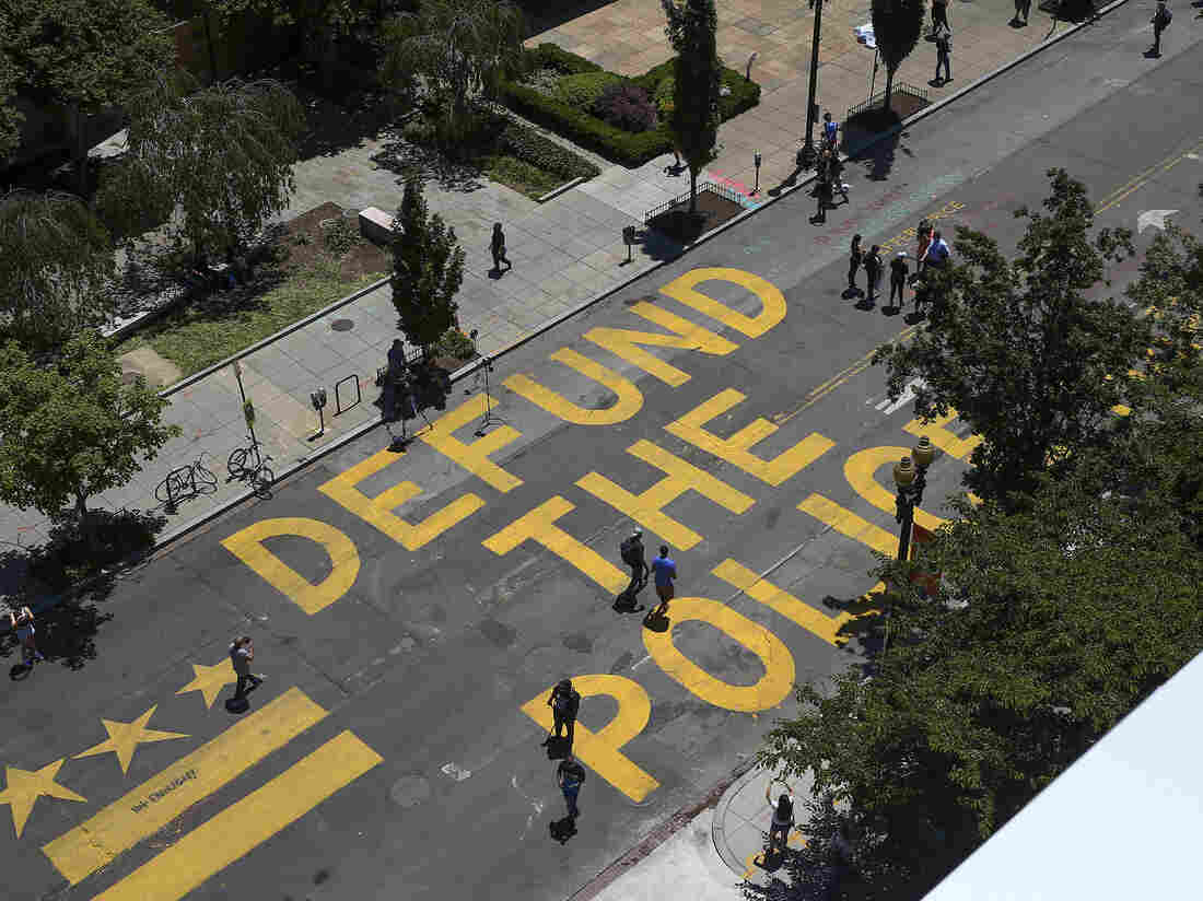 People walk down 16th street after "Defund The Police" was painted on the street near the White House on June 08, 2020 in Washington, DC. (Photo by Tasos Katopodis/Getty Images)