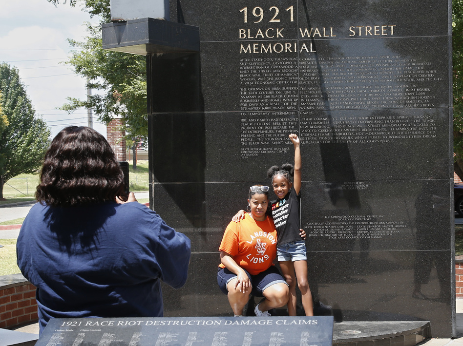 Katrina Cotton, center, of Houston poses for a photo Monday with her daughter, Kennedy Cotton, 7, at the Black Wall Street Memorial in Tulsa, Okla. (Sue Ogrocki/AP)