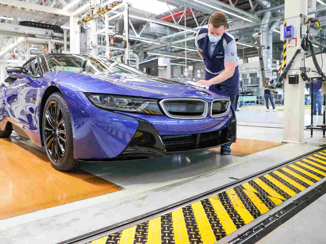 11 June 2020, Saxony, Leipzig: An employee wipes the last BMW i8 with a cloth at the end of the production line. (Photo by Jan Woitas/picture alliance via Getty Images)