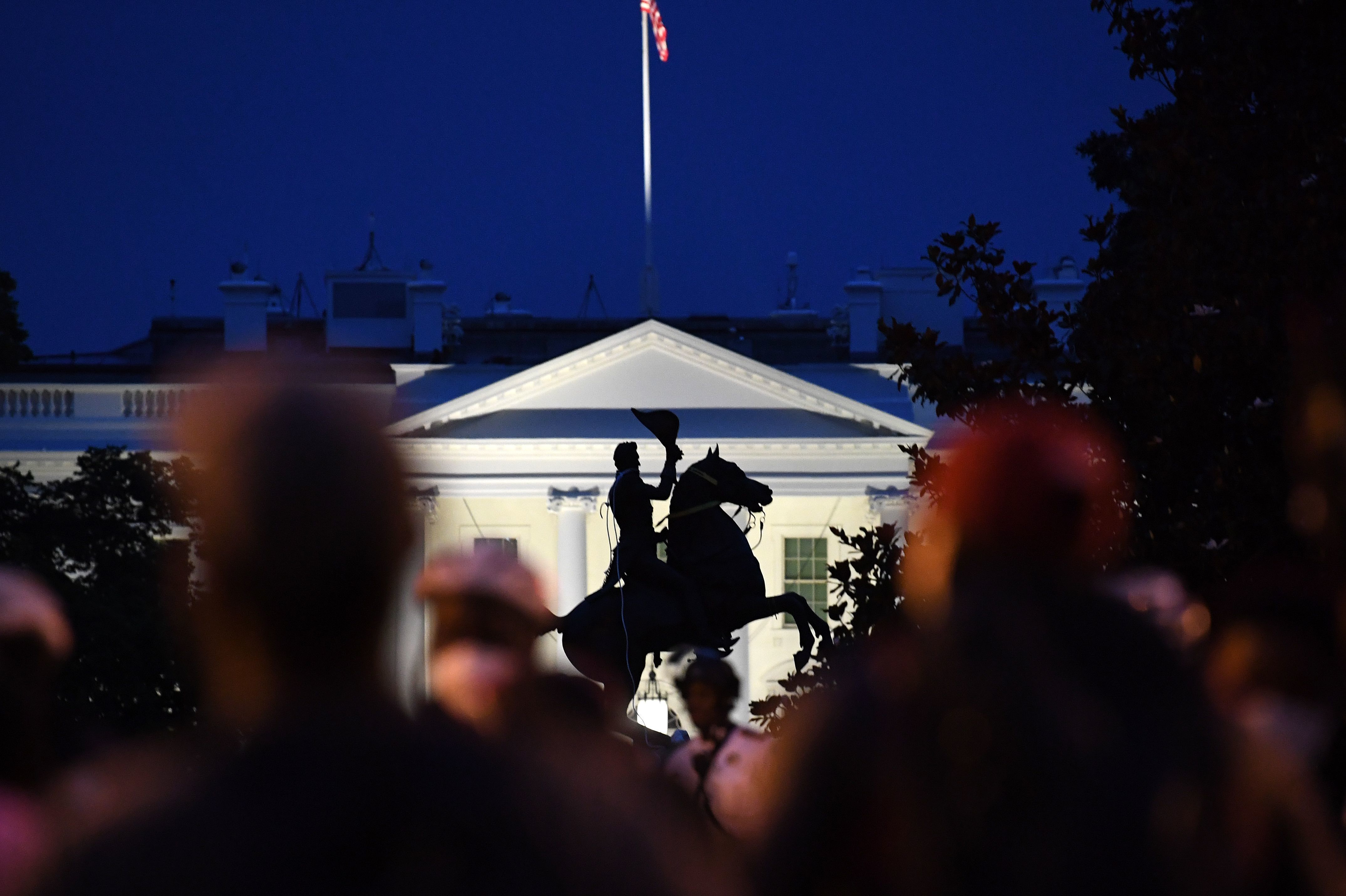 Police officers stand guard with the statue of Andrew Jackson after protesters tried to topple it at Lafayette Square in front of the White House on Monday night. Police responded with pepper spray to break up the demonstration. (AFP via Getty Images)