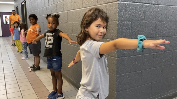 To help with social distancing, children at Valley of the Sun YMCA sites in Arizona were taught to make "airplane arms" when standing in line.