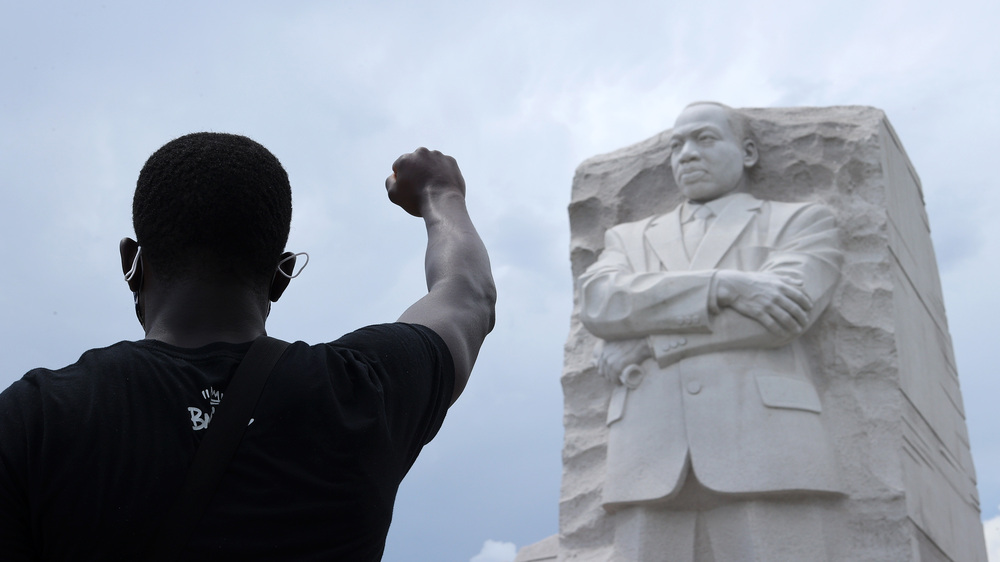 A man kneels and raises his fist in the air during a march and protest to mark the Juneteenth holiday at the Martin Luther King Jr. Memorial June 19, 2020 in Washington, DC. (Getty Images)