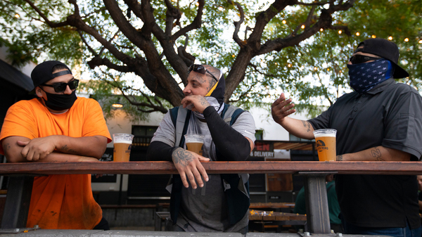 With new coronavirus infections climbing in most states, infectious disease experts are discouraging group get-togethers, especially those that involve drinking. In this photo patrons enjoy a beer outside the Central Market in Los Angeles, this week.