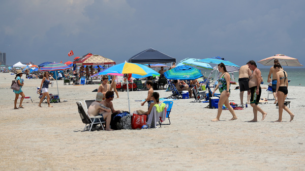 People visit Jacksonville Beach on Saturday in Jacksonville Beach, Florida. Coronavirus cases are spiking in states including Florida, Texas and Arizona.
