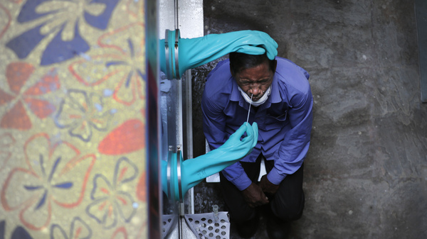 A health worker takes a nasal swab of a person for COVID-19 at a hospital in New Delhi, India. India has overtaken Russia to become the third worst-affected nation by the coronavirus pandemic.