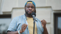 "People started screaming and shouting for them to let me go," says Vauhxx Booker, who says he was assaulted by a group of white men on July 4. Booker is seen here speaking at a community gathering against racism, where protesters demanded charges in his case.