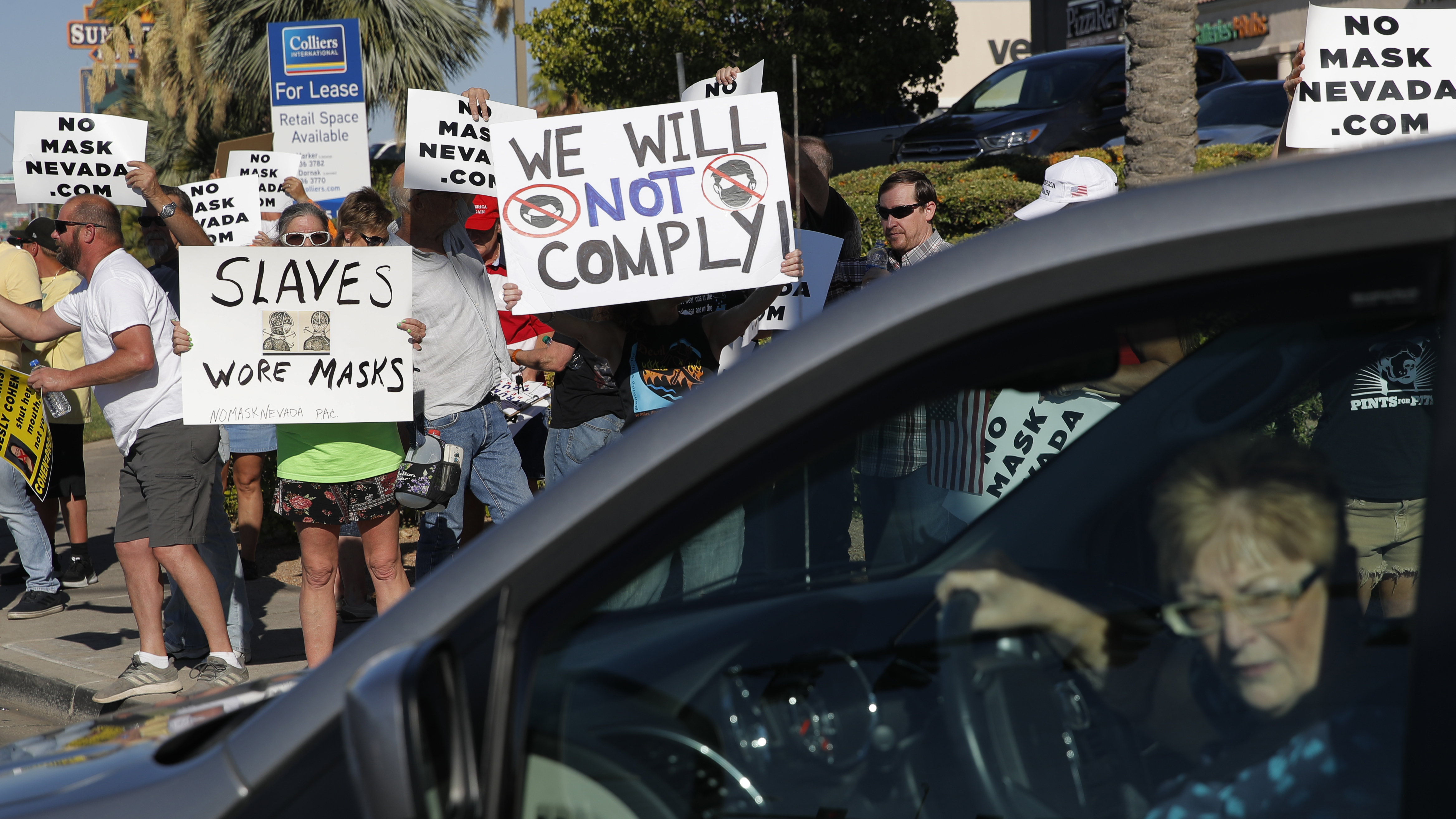 People protest Nevada's public mask mandate in Henderson, Nev., on Wednesday. Gov. Steve Sisolak issued a mandatory face covering policy for public spaces throughout the state due to concerns over the spread of the coronavirus.
