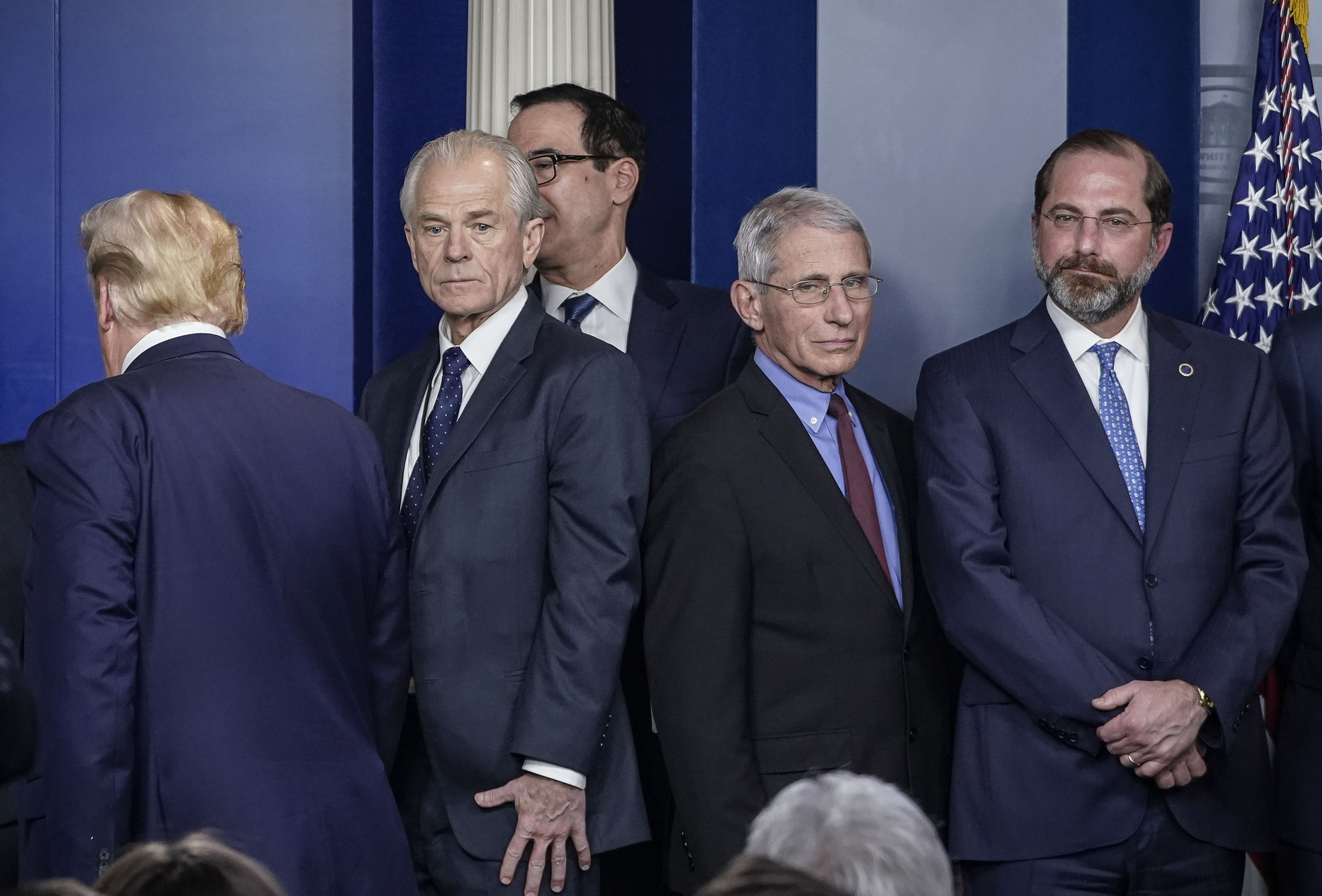 White House economic adviser Peter Navarro (center, left) and Dr. Anthony Fauci, director of the National Institute of Allergy and Infectious Diseases, stand back to back after a White House Coronavirus Task Force briefing on March 9. Navarro wrote an opinion article this week criticizing Fauci. (Getty Images)