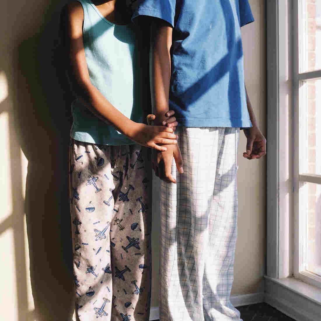 Thandi and Khaya holding each other while wearing pajamas.