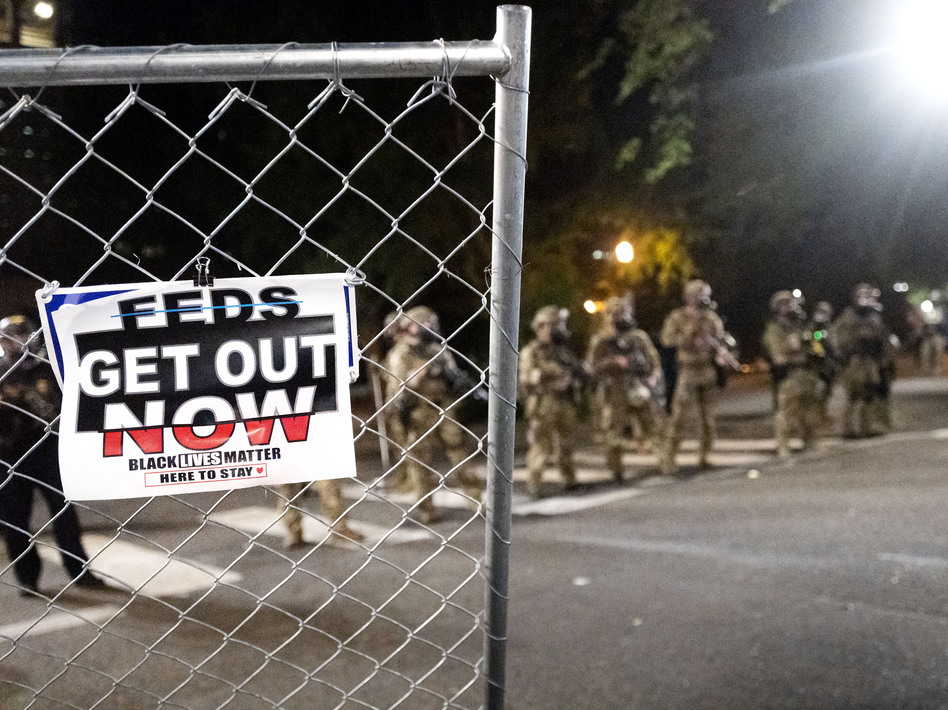 Federal agents disperse protesters near the Mark O. Hatfield U.S. Courthouse on Monday in Portland, Ore. State and local officials say the federal law enforcement officers have incited violence in the city. (Noah Berger/AP)