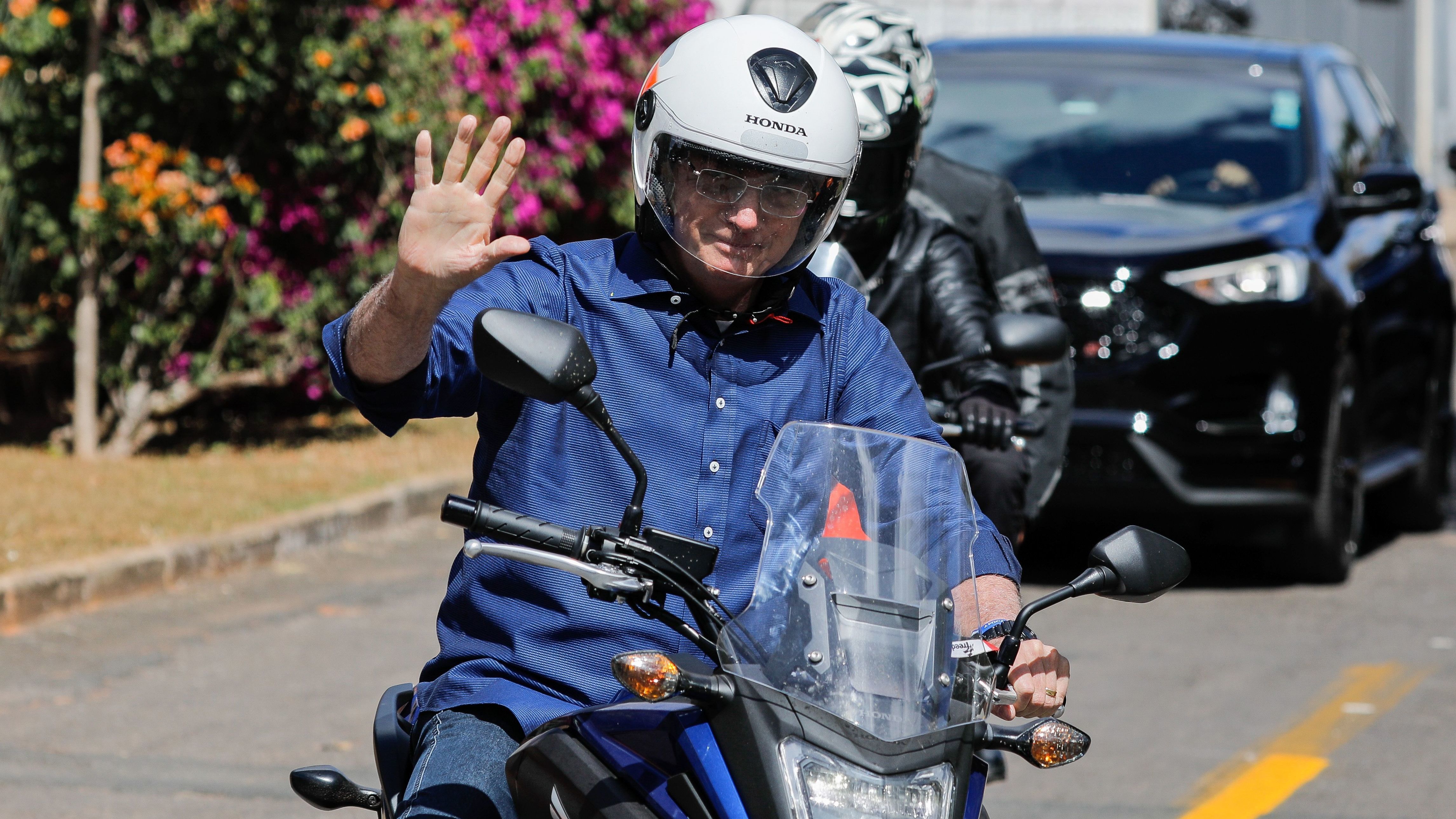 Brazilian President Jair Bolsonaro takes a ride on a motorcycle Saturday in Brasilia after he announced he tested negative for the coronavirus. He had tested positive earlier this month. (AFP via Getty Images)