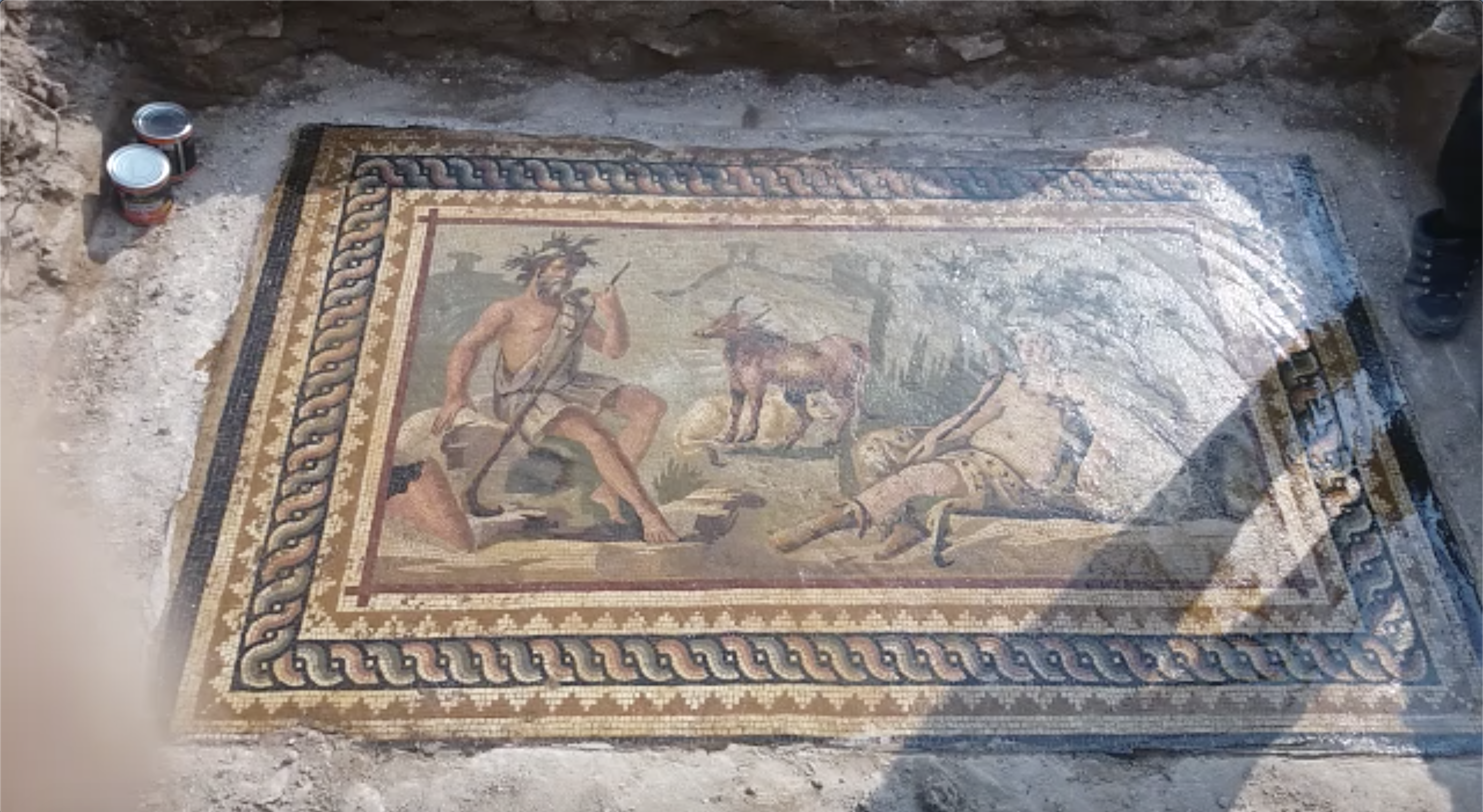 A screenshot from a video from a Facebook group devoted to looting and selling antiquities. A narrator speaking Syrian-accented Arabic describes an elaborate, Roman-era mosaic depicting mythological figures and animals believed to be in northwestern Syria – a conflict zone where there has been extensive looting of illegally excavated antiquities. (ATHAR Project/Screenshot by NPR)