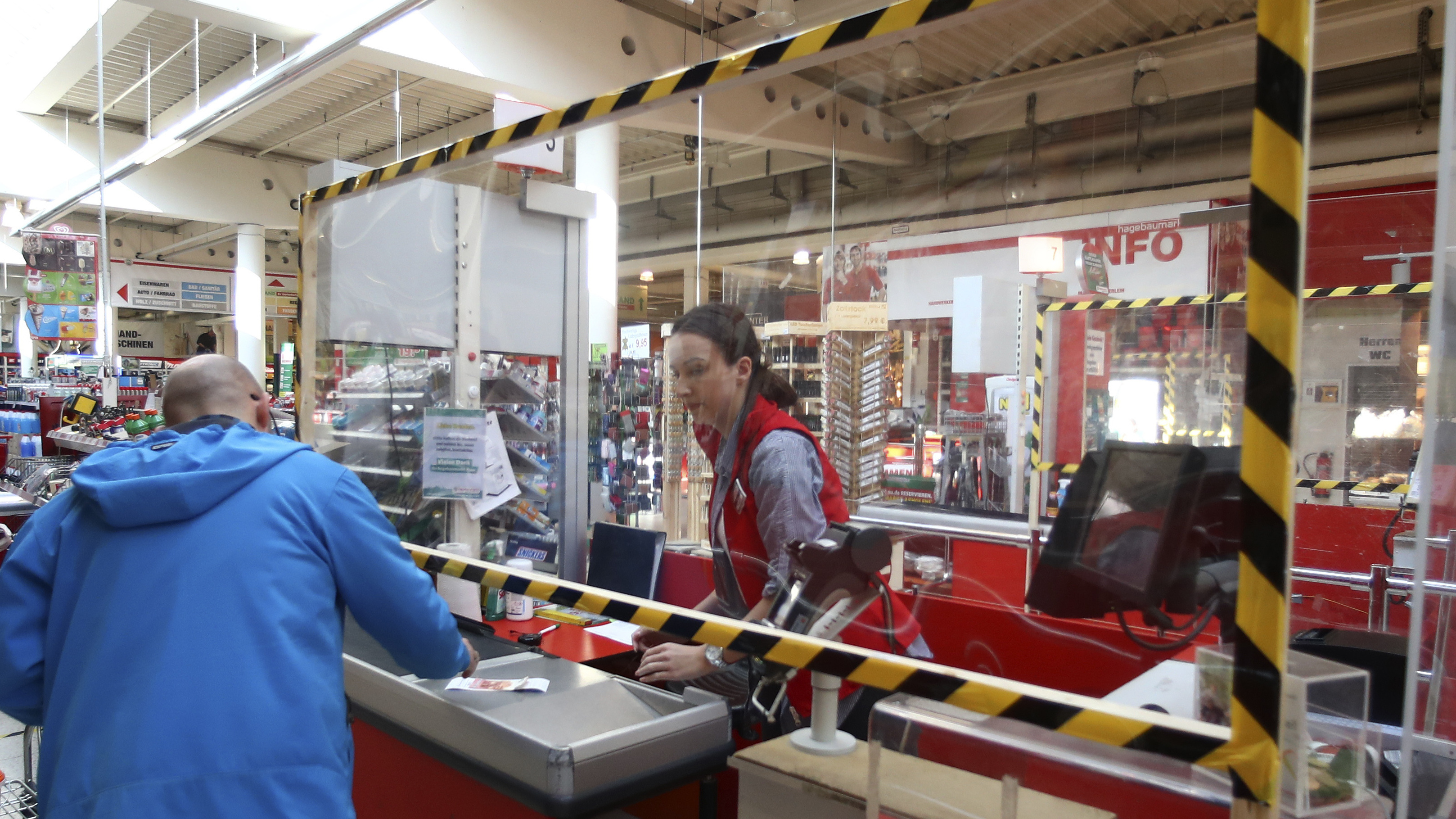 A cashier accepts payment from a customer in Munich in March.