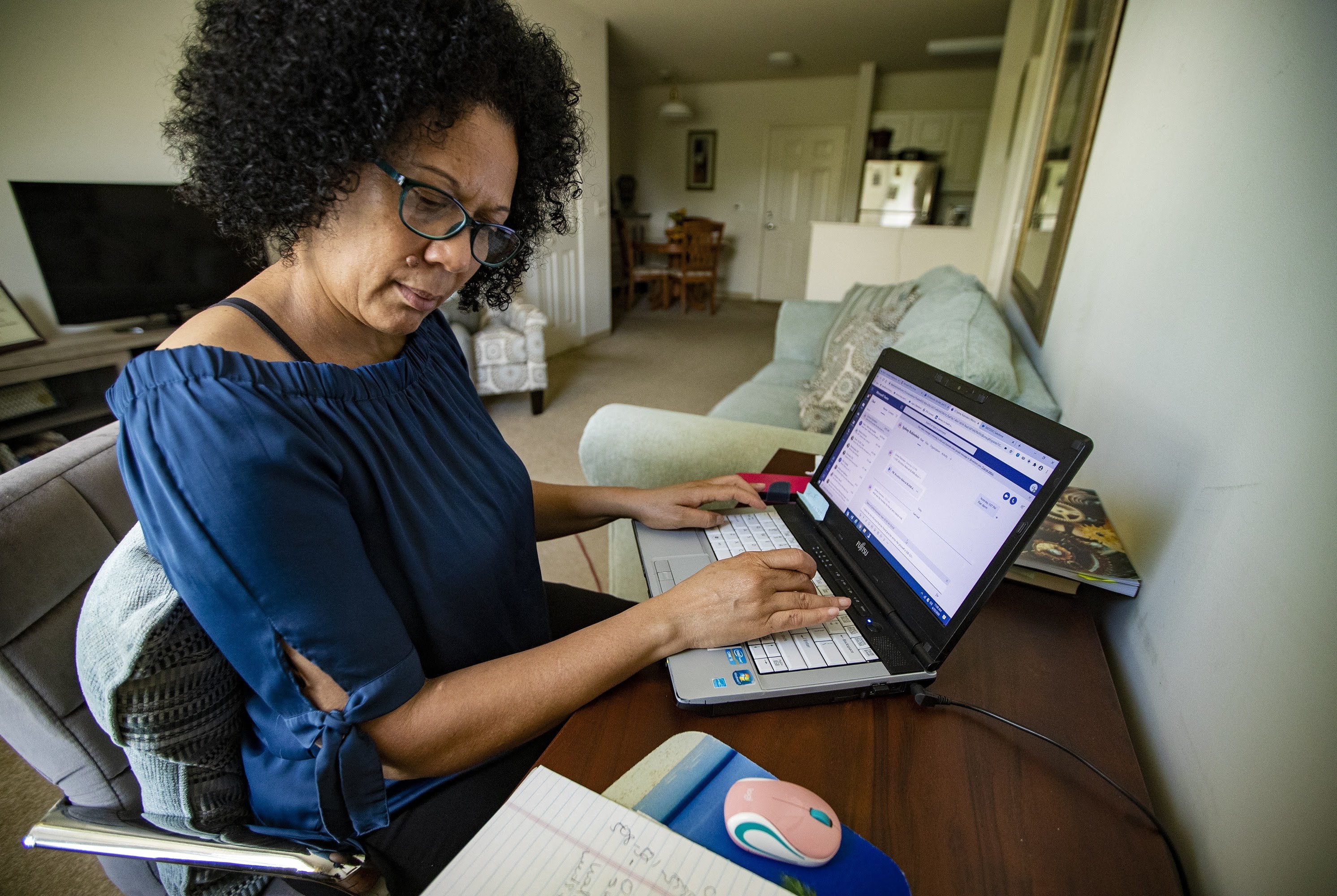 Care resource coordinator Luisa Schaeffer scrolls through her COVID-19 isolation case list for the day: One woman is out of milk, while another needs help finding a doctor and making an appointment. A man also asks about getting help to pay rent. (Jesse Costa/WBUR)