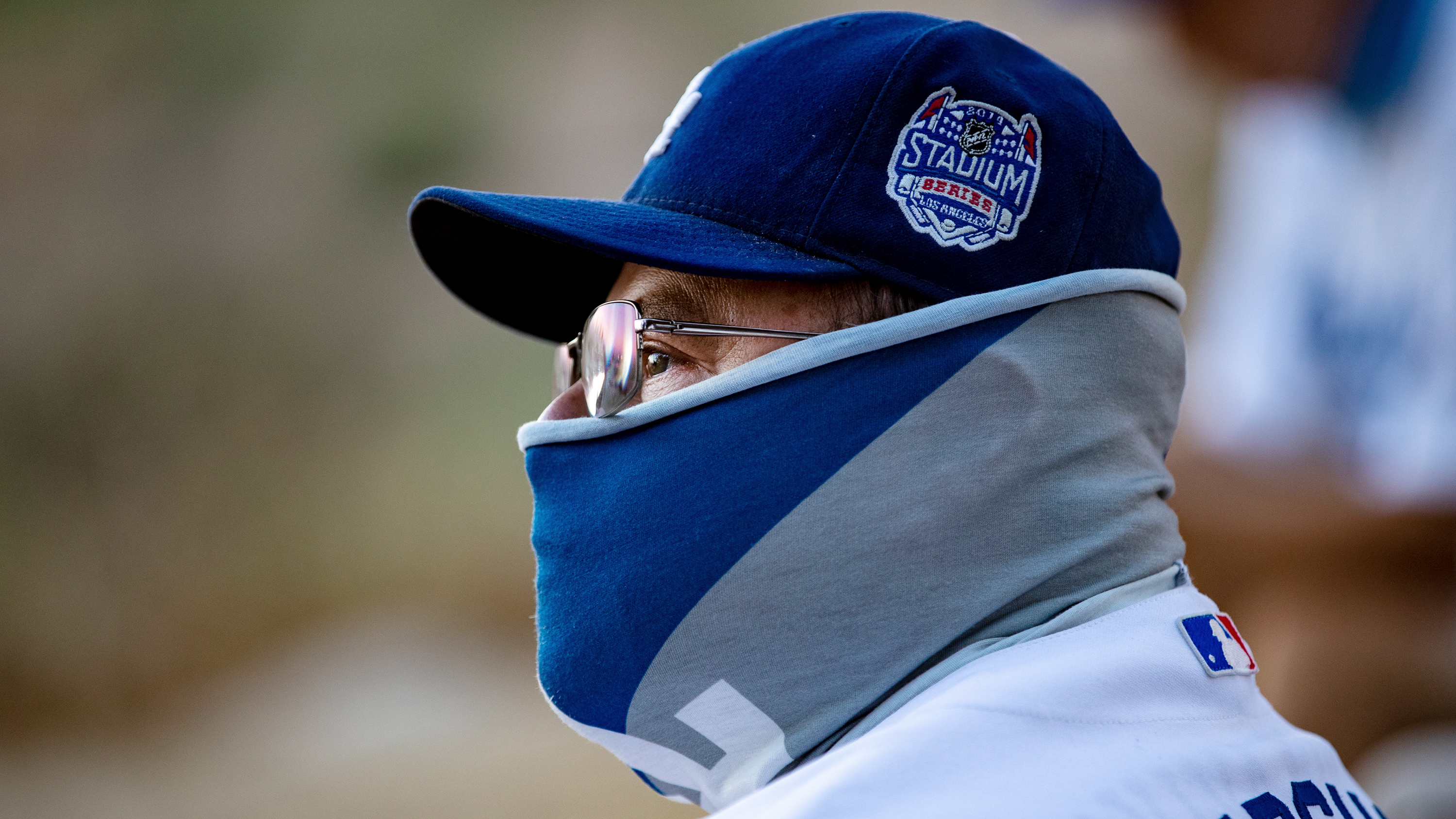 A fan wears a neck gaiter as he watches the L.A. Dodgers play the San Francisco Giants in Los Angeles.