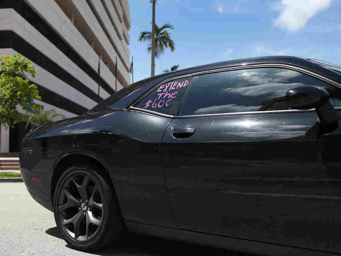 A car with "extend the $600!" written on a window participates in a protest on July 16, 2020 in Miami Springs, Florida.